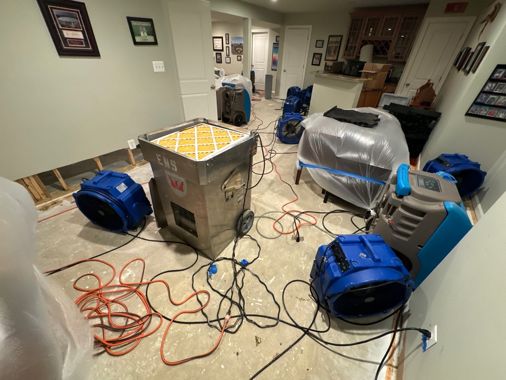 Continued drying phase with equipment monitoring moisture levels in water-damaged Alexandria residential space.
