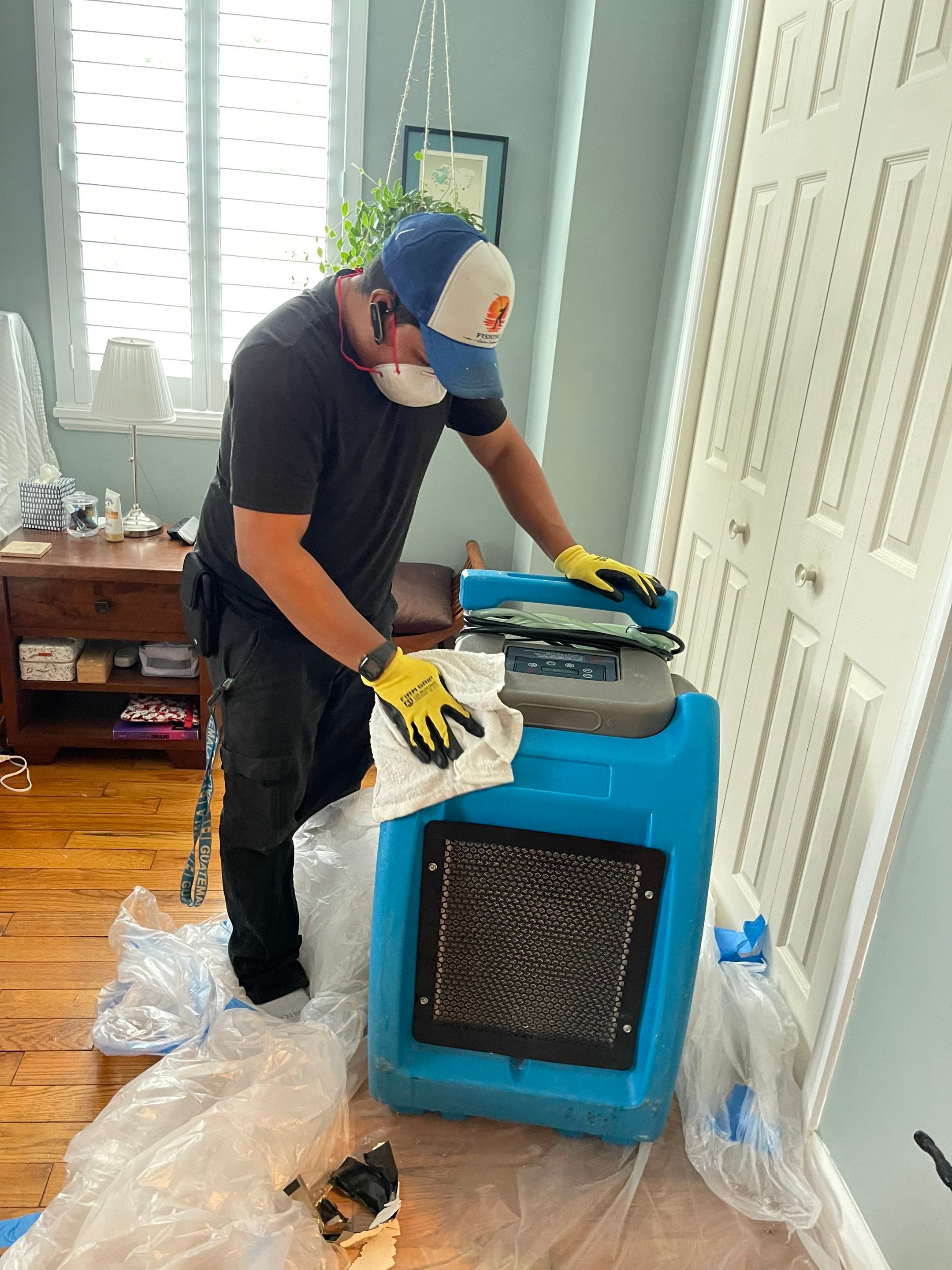 Mid-stage drying setup showing dehumidifiers and air movers working to extract moisture from affected flooring.