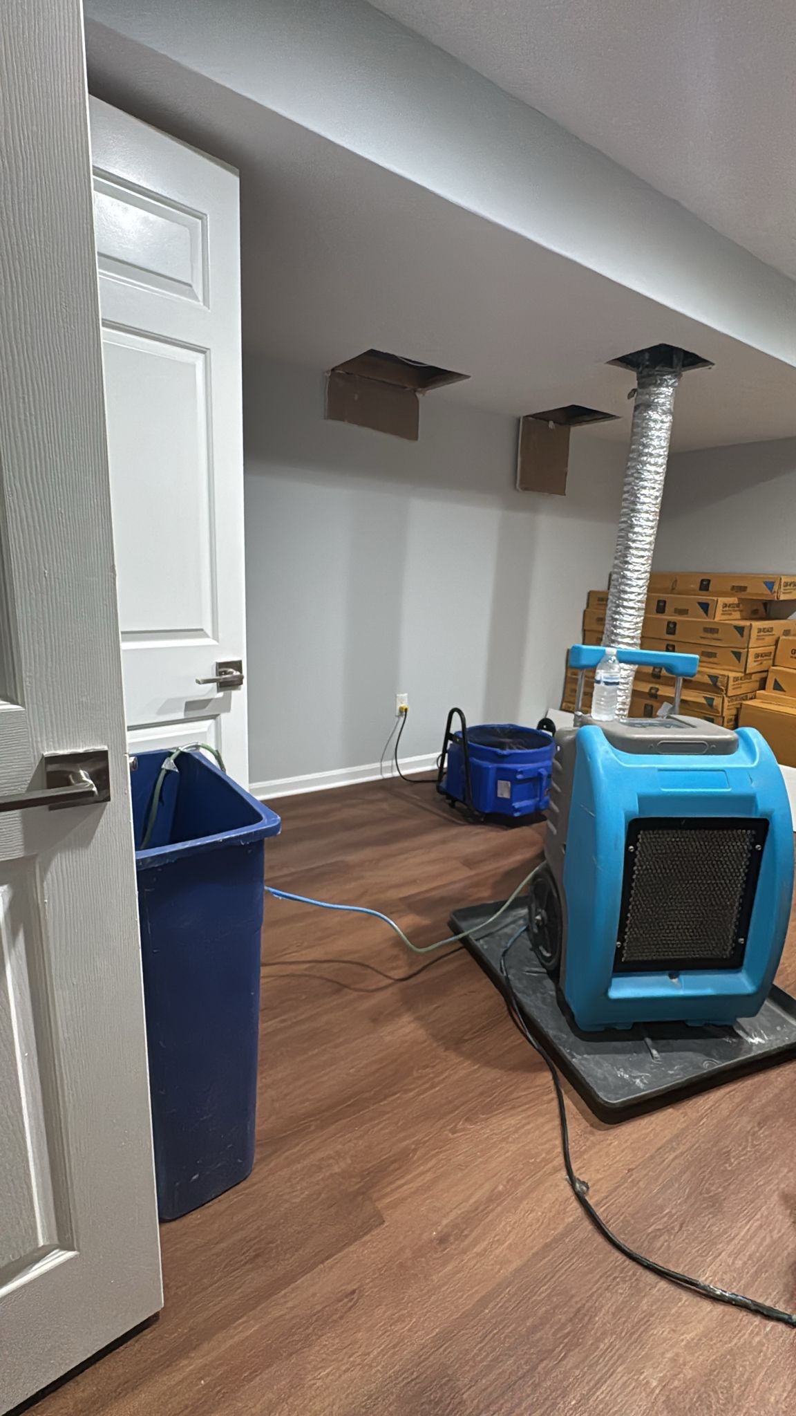 Standing water extraction underway in Fairfax water damage restoration, removal equipment deployed across affected floor.