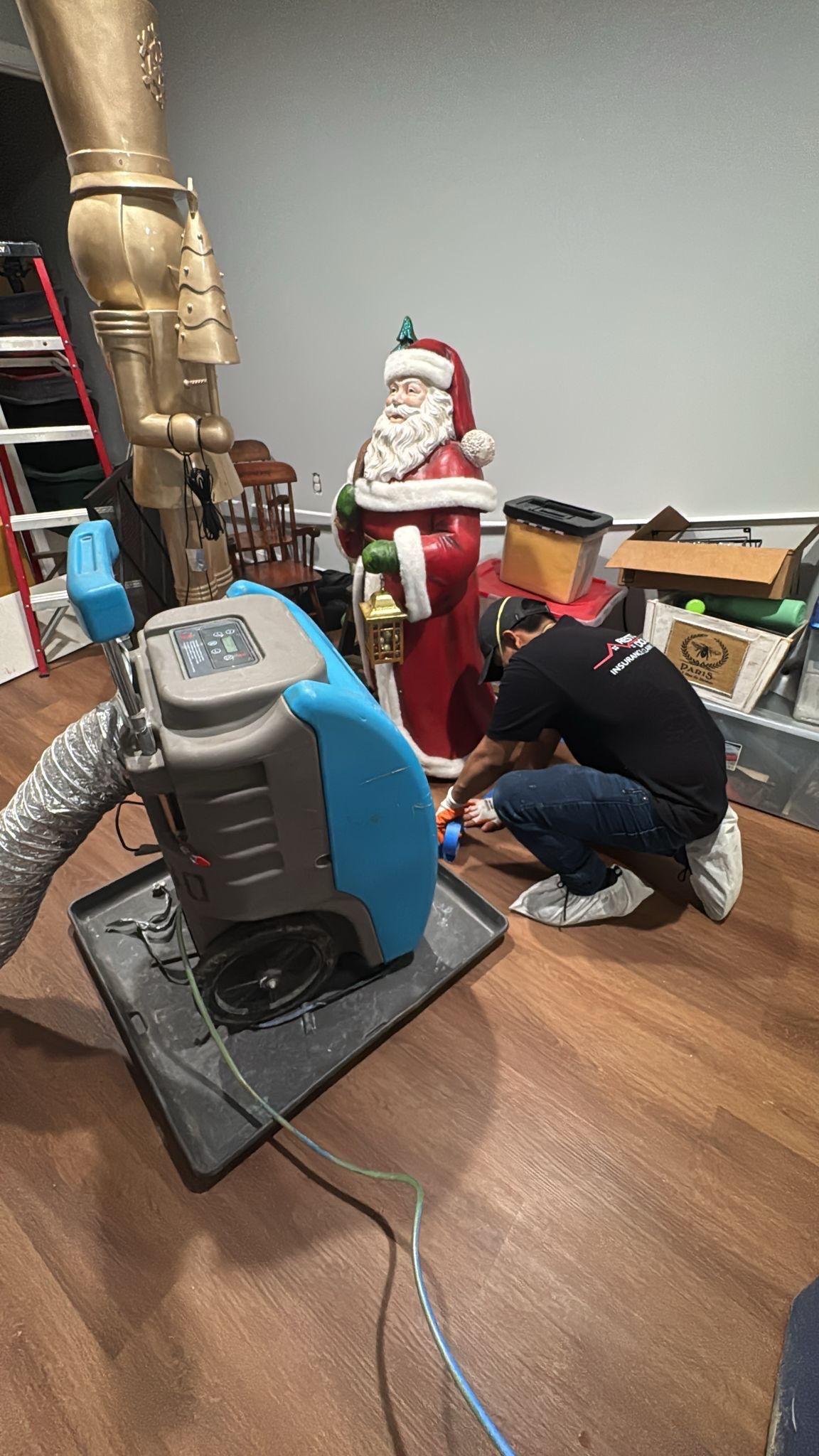 Dehumidification units positioned throughout interior space during mid-stage water restoration drying process.