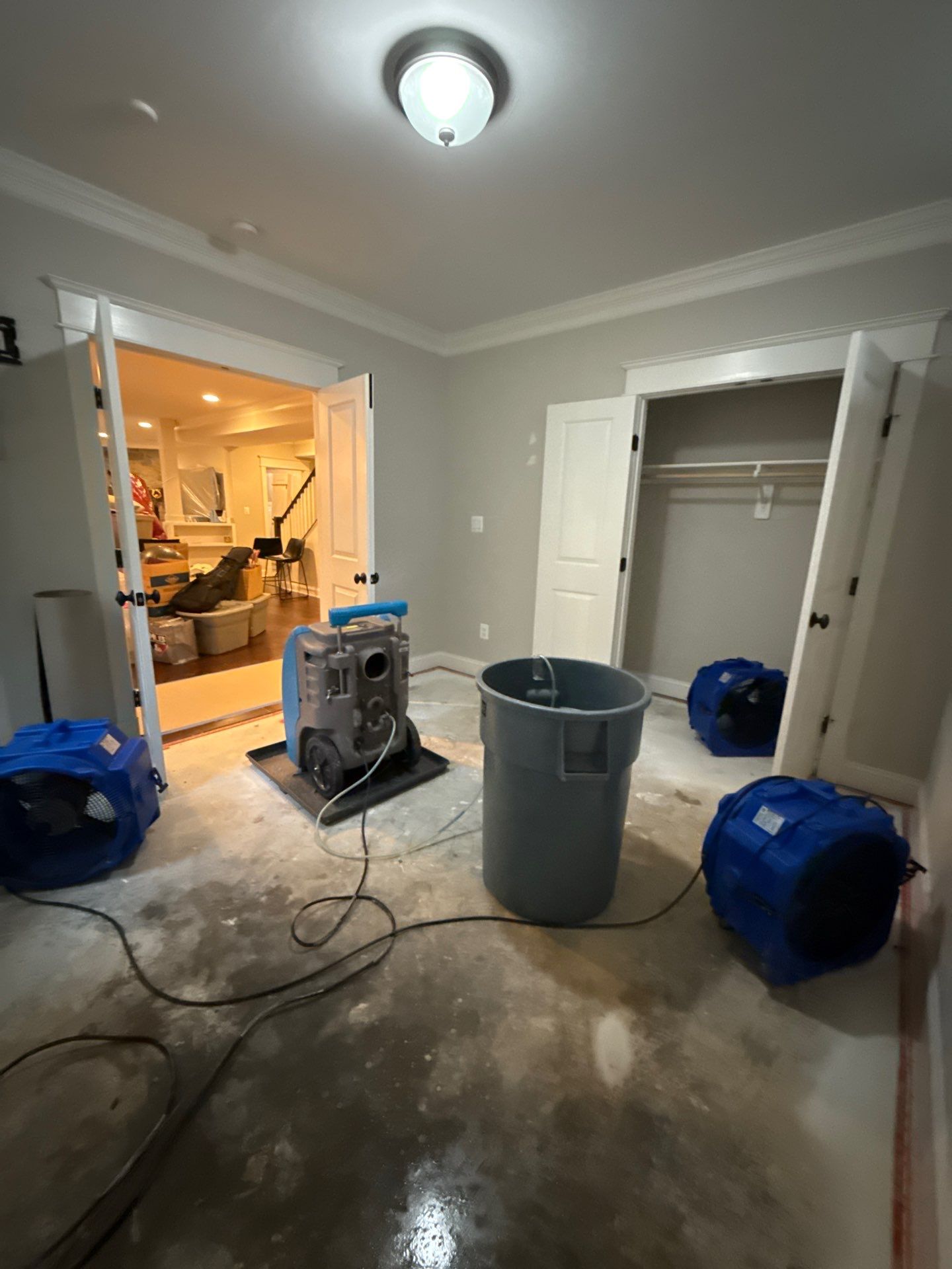 Water damage restoration in Arlington: wet carpet and flooring with structural drying equipment deployed.