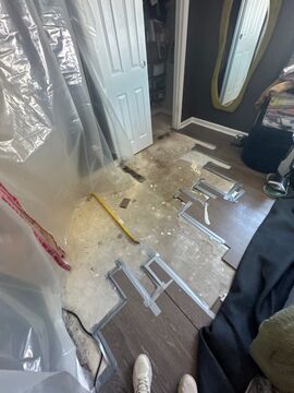 Water-damaged carpet and flooring in Sterling home with dehumidification equipment positioned for structural drying.