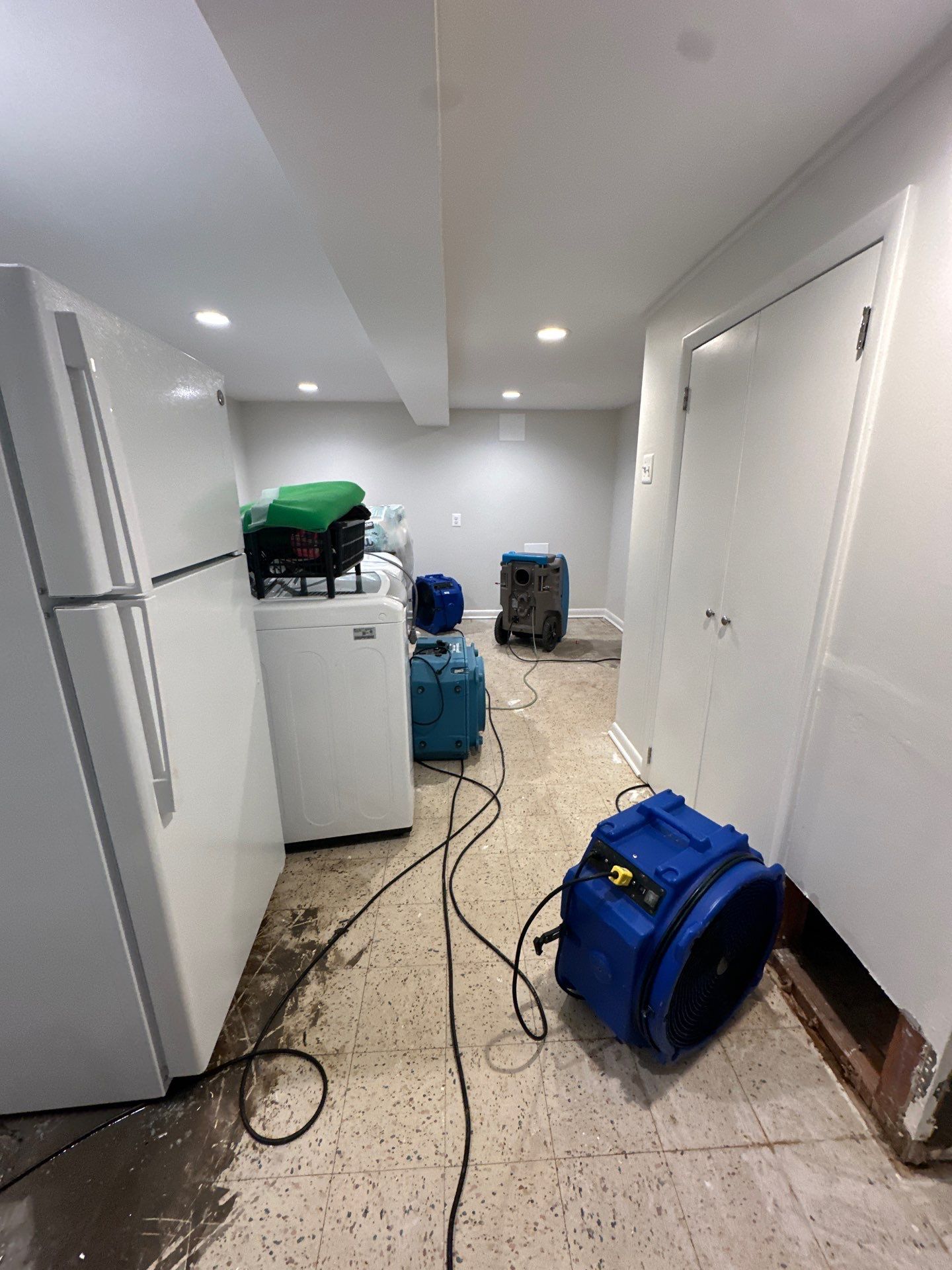Water damage restoration in Falls Church: dehumidification and structural drying equipment deployed in affected interior space.