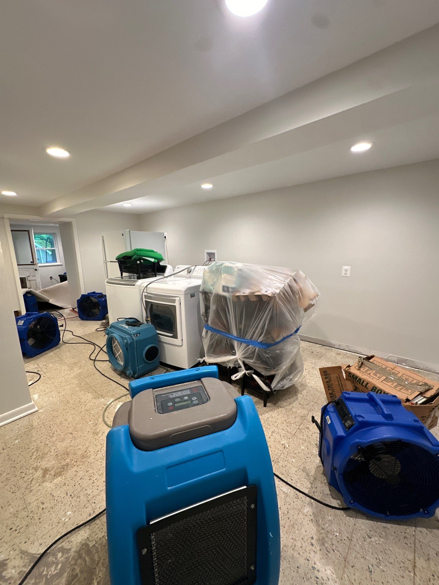 Mid-stage drying operation showing moisture extraction and air circulation setup during water restoration work.