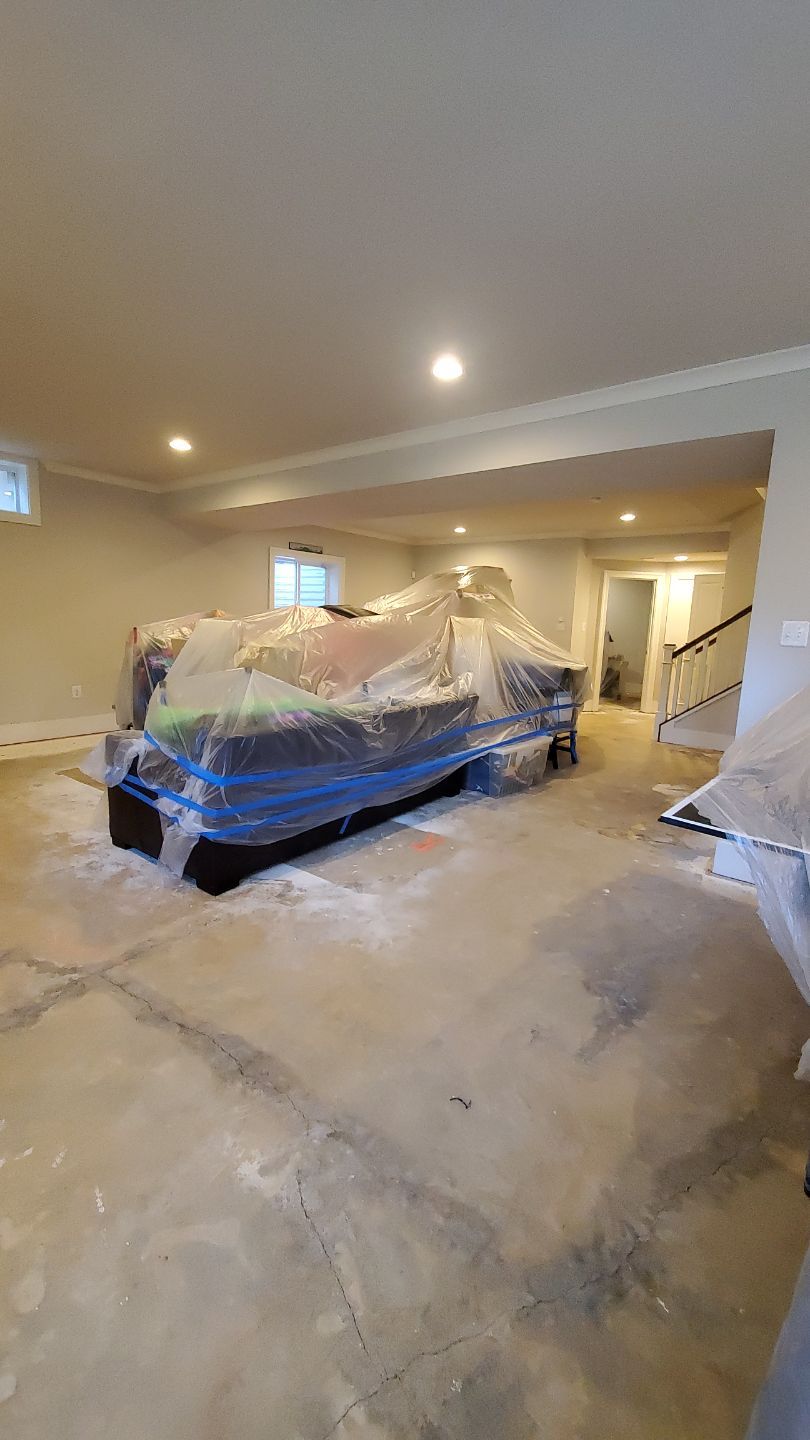 Standing water extraction underway in Arlington water damage restoration, wet flooring and walls visible.
