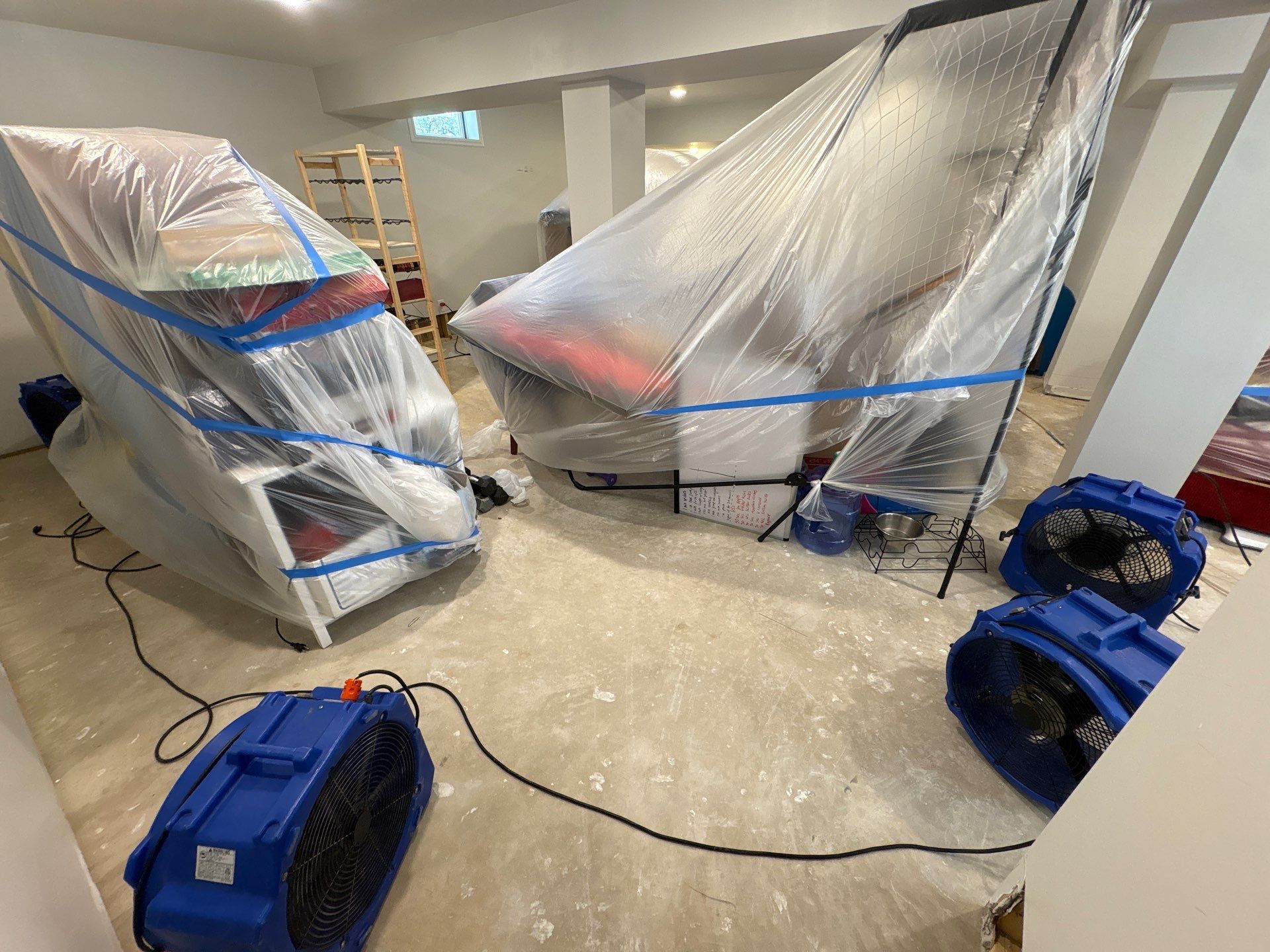 Dehumidifiers and air movers positioned throughout affected areas to manage moisture extraction.