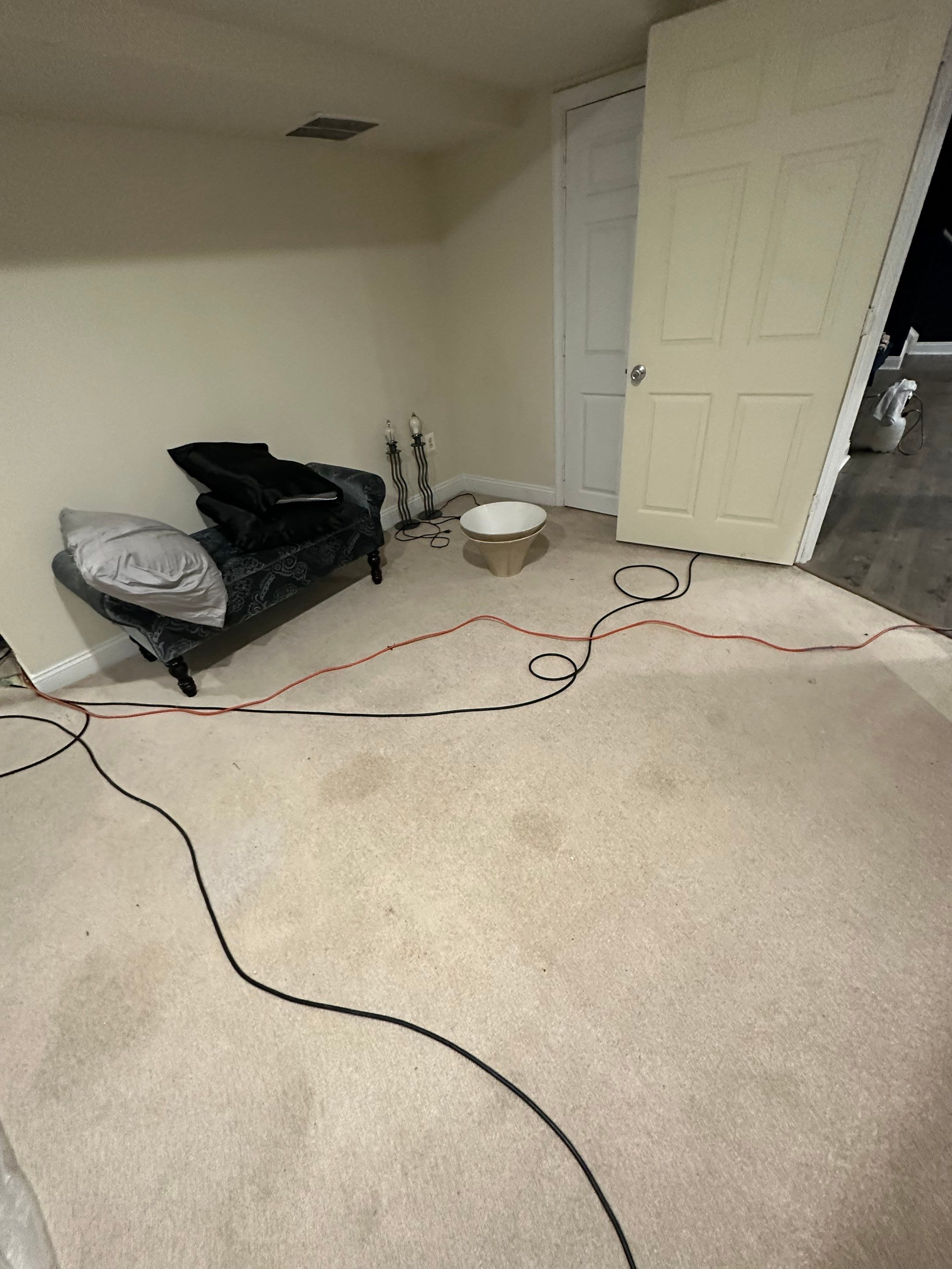 Water damage restoration in Montclair: dehumidifier and drying equipment positioned in affected room during initial assessment.