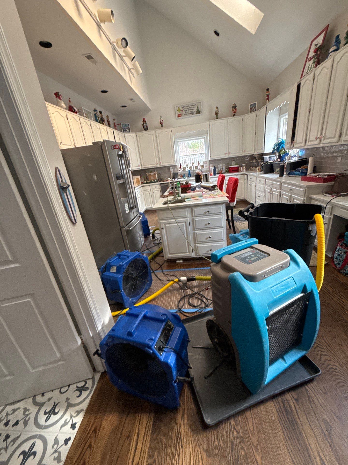 Ceiling repair underway during Fairfax water damage restoration, with drying equipment still in place.
