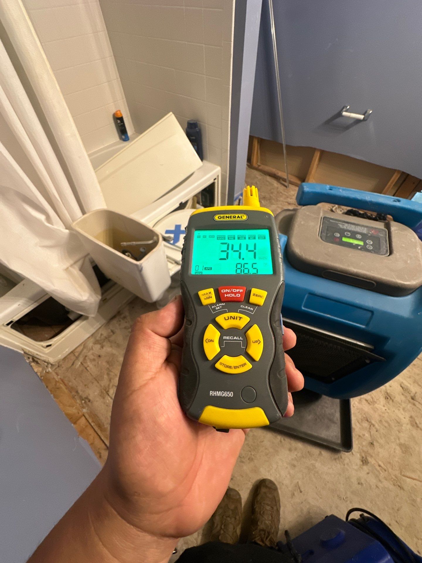 Technician monitoring thermal readings across affected building materials.