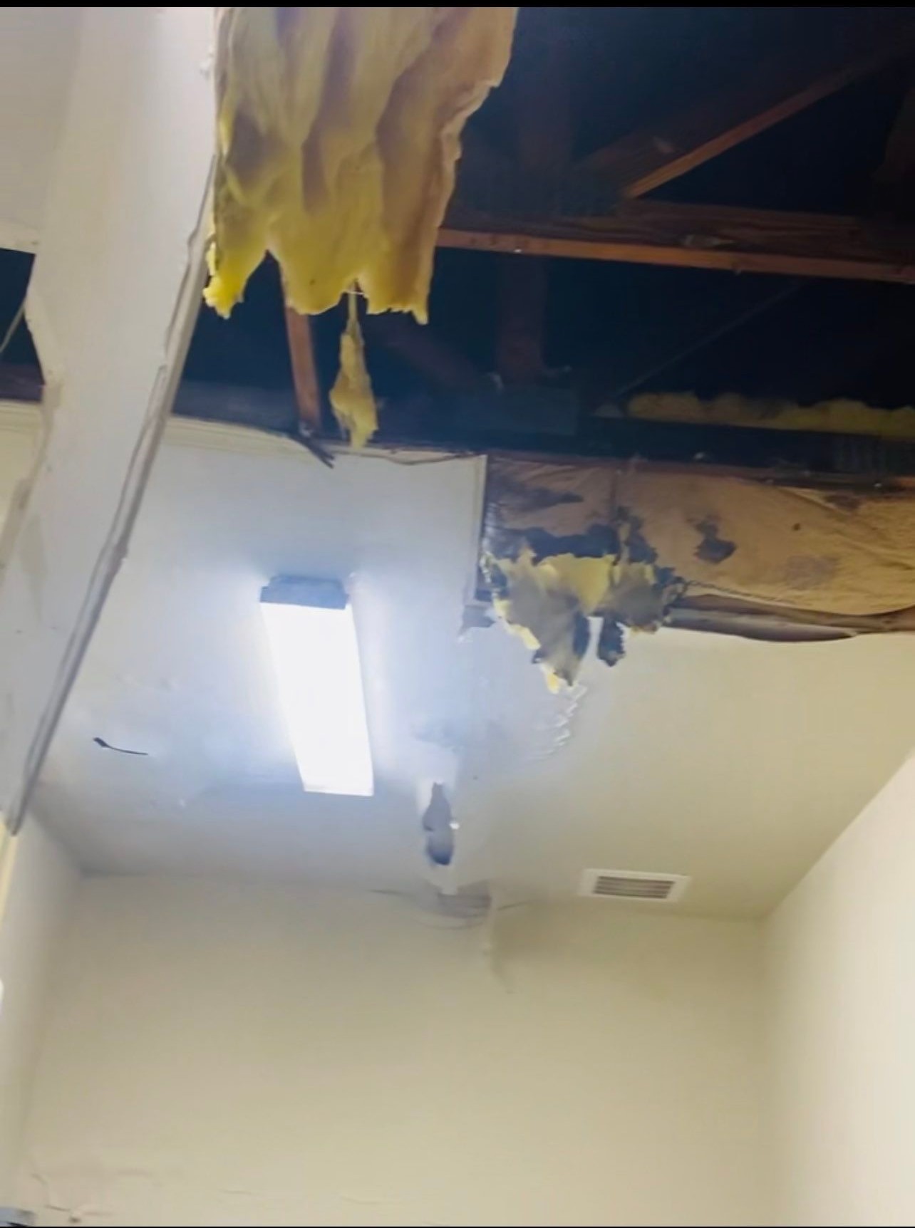 Water damage restoration in Leesburg: dehumidifier and drying equipment positioned in affected room during initial assessment.