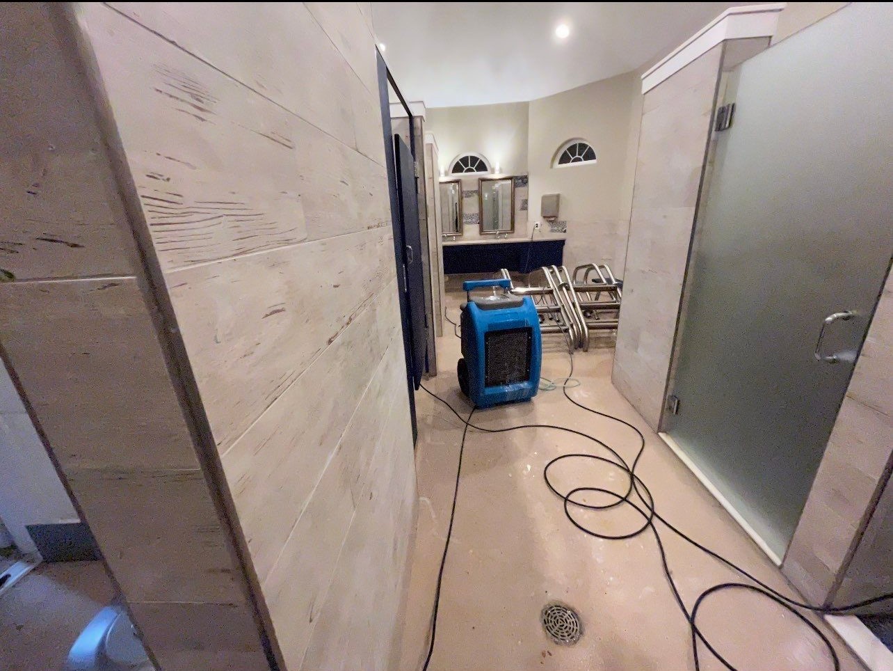 Drying equipment monitoring moisture levels during mid-stage structural drying and remediation.