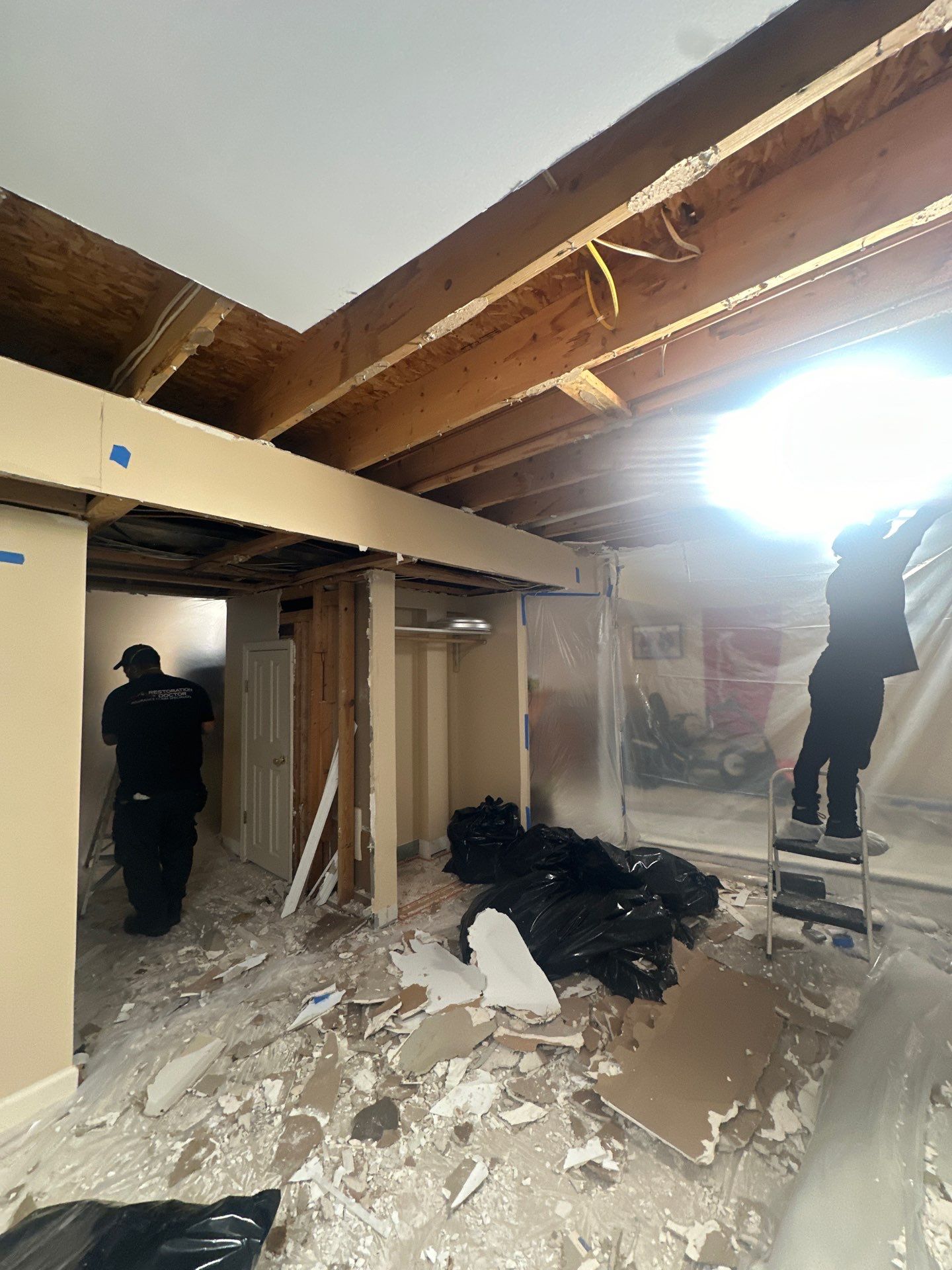 Mid-stage drying showing containment barrier maintaining controlled environment for water damage restoration.
