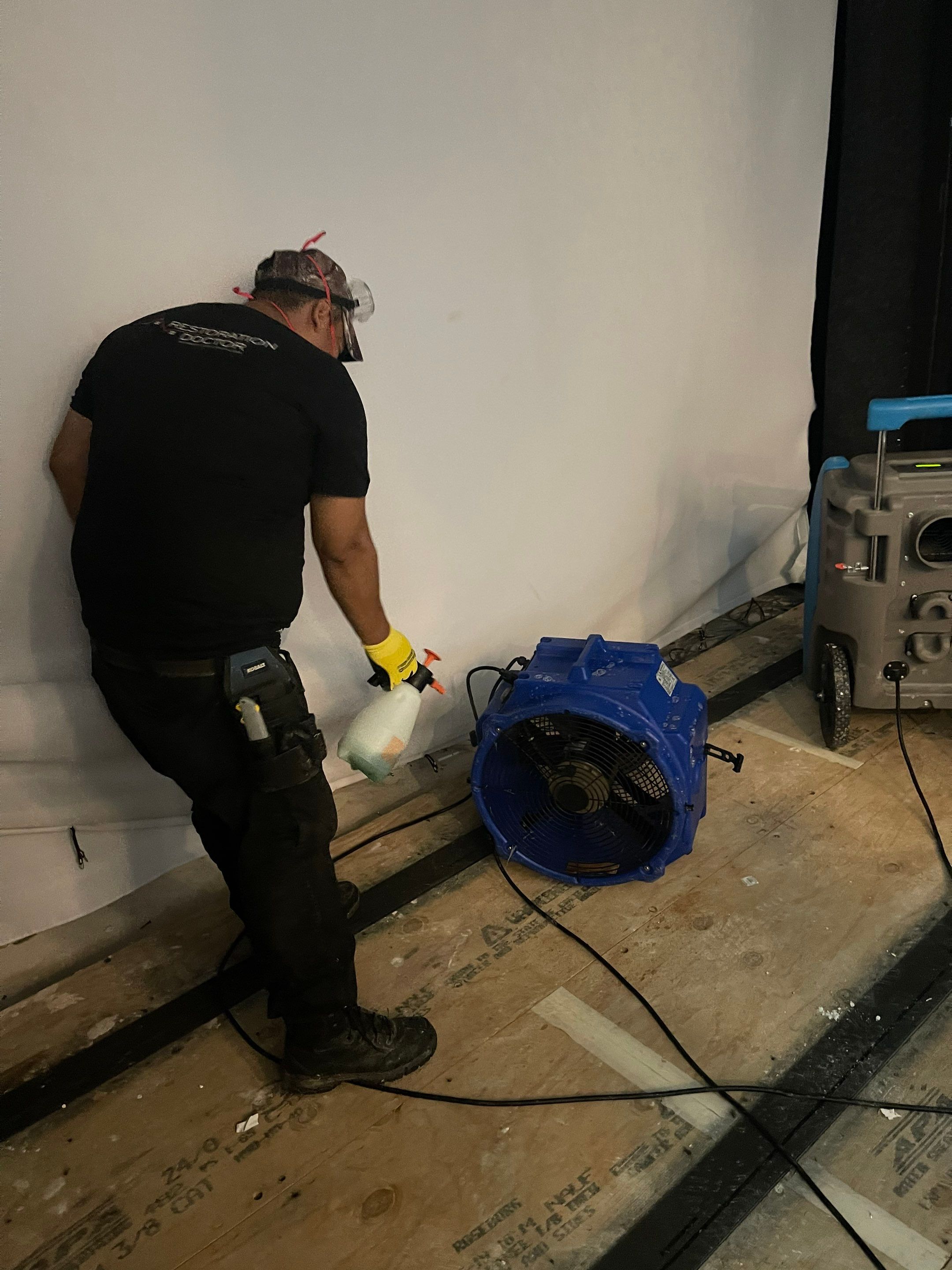 Dehumidifier and air movers positioned for structural drying during water restoration.