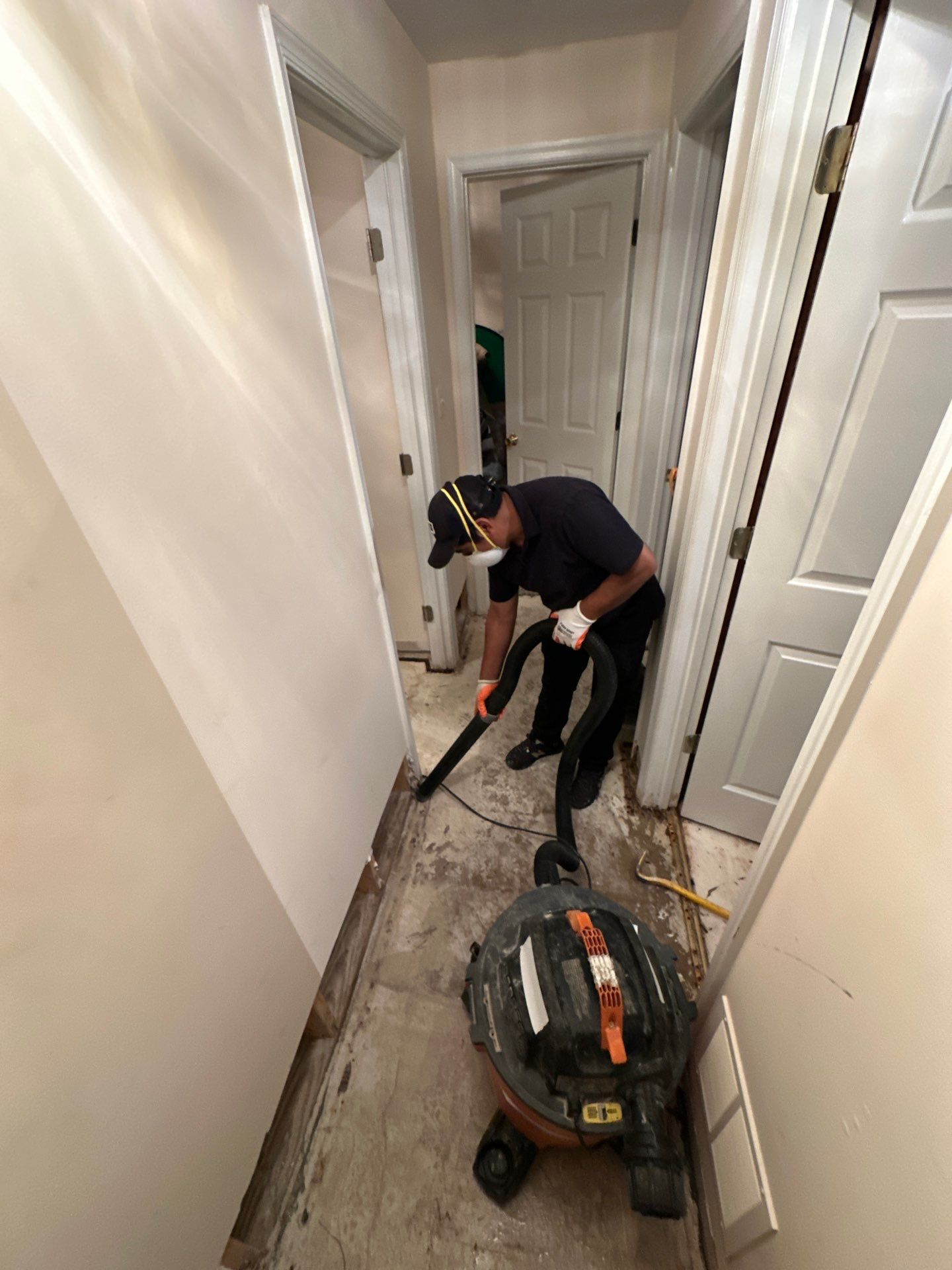 Standing water extraction underway in Sterling water damage restoration, wet carpet and flooring visible.