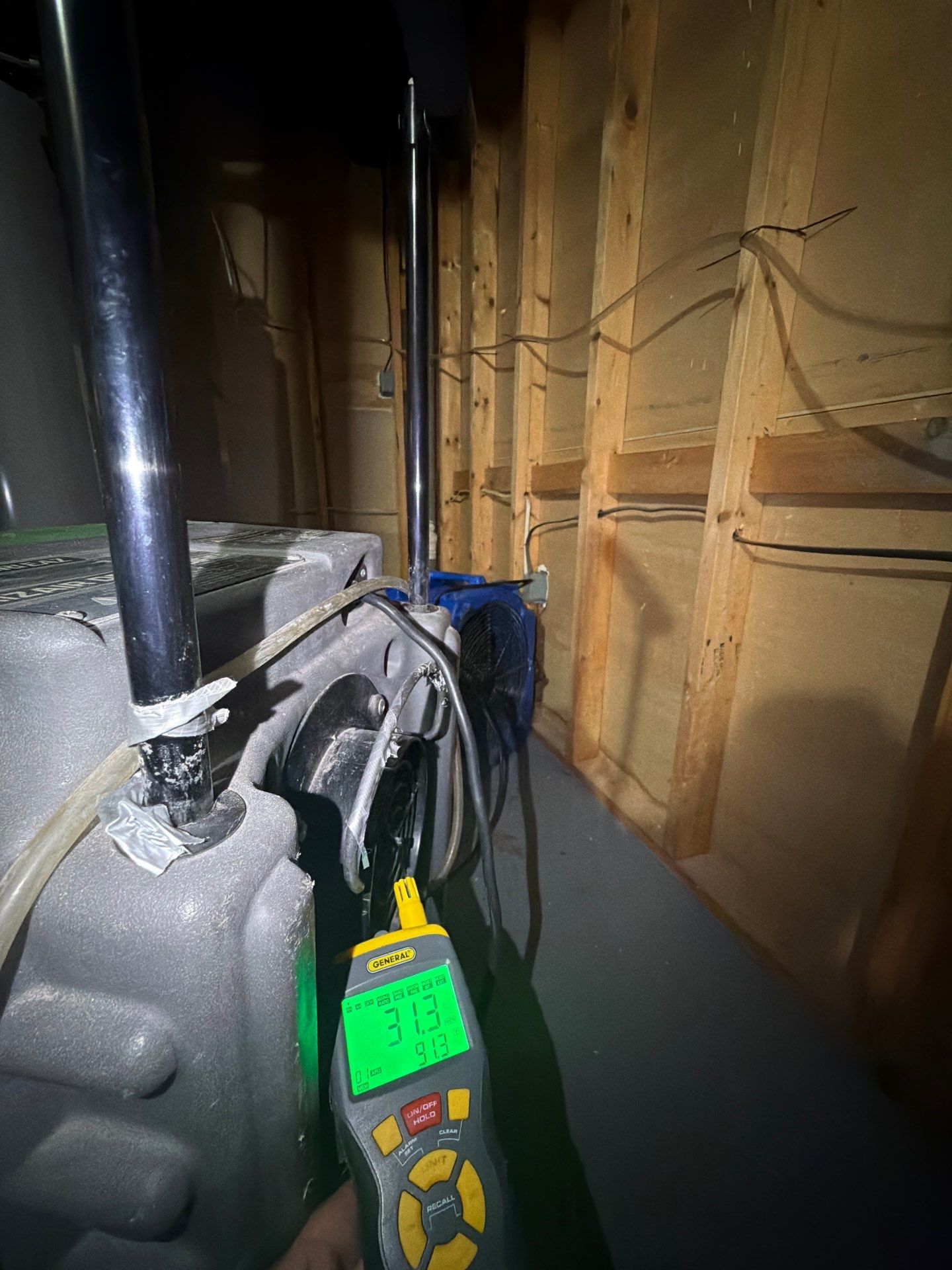 Wet baseboards and wall cavity exposed during water damage assessment and drying.