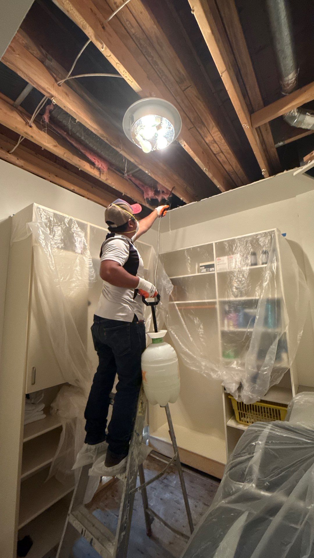 Dehumidifiers and air movers working in sealed containment area to manage humidity during water restoration.