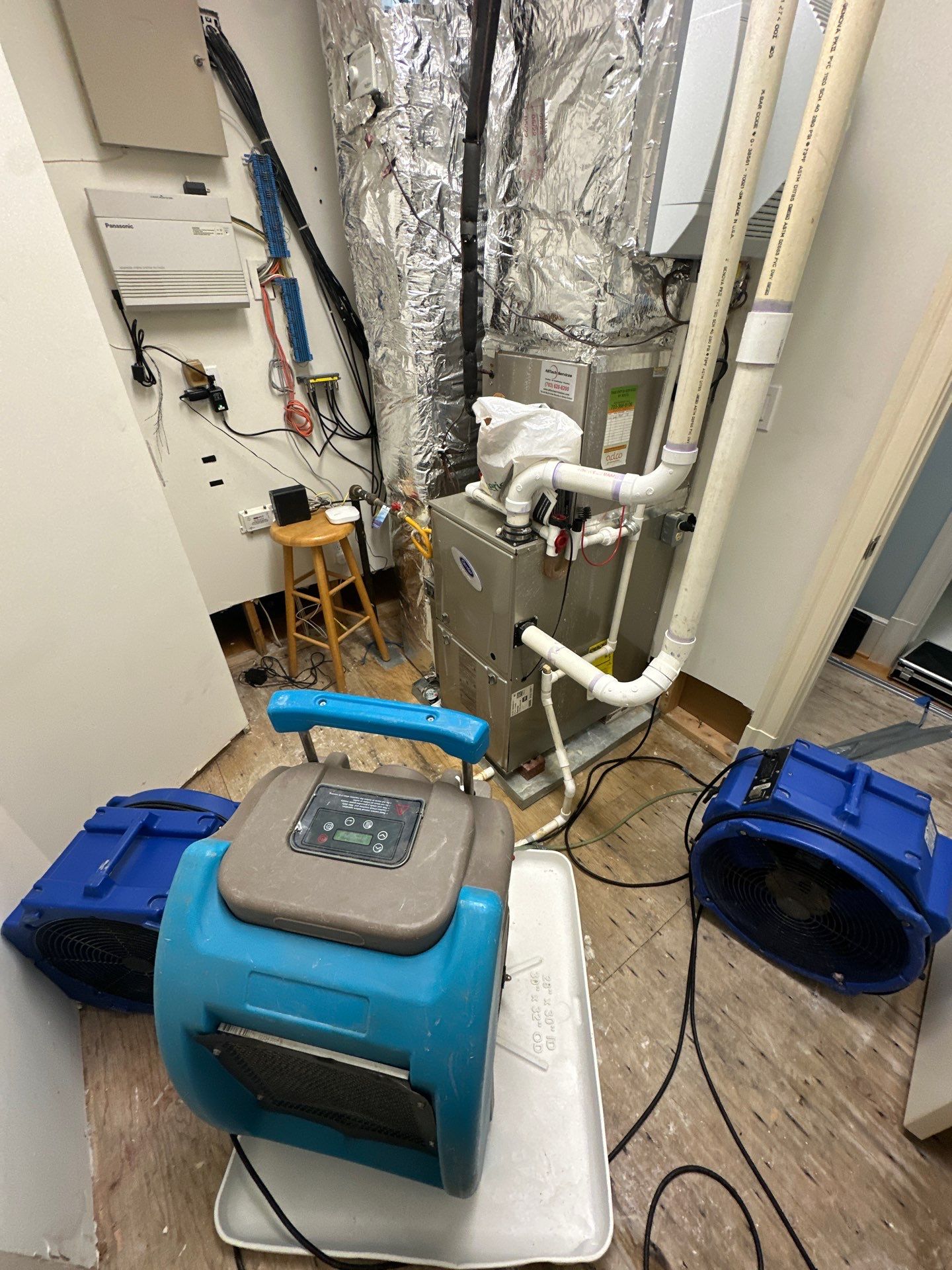 Plastic containment barrier isolates water damage zone in Church home during initial assessment and setup.
