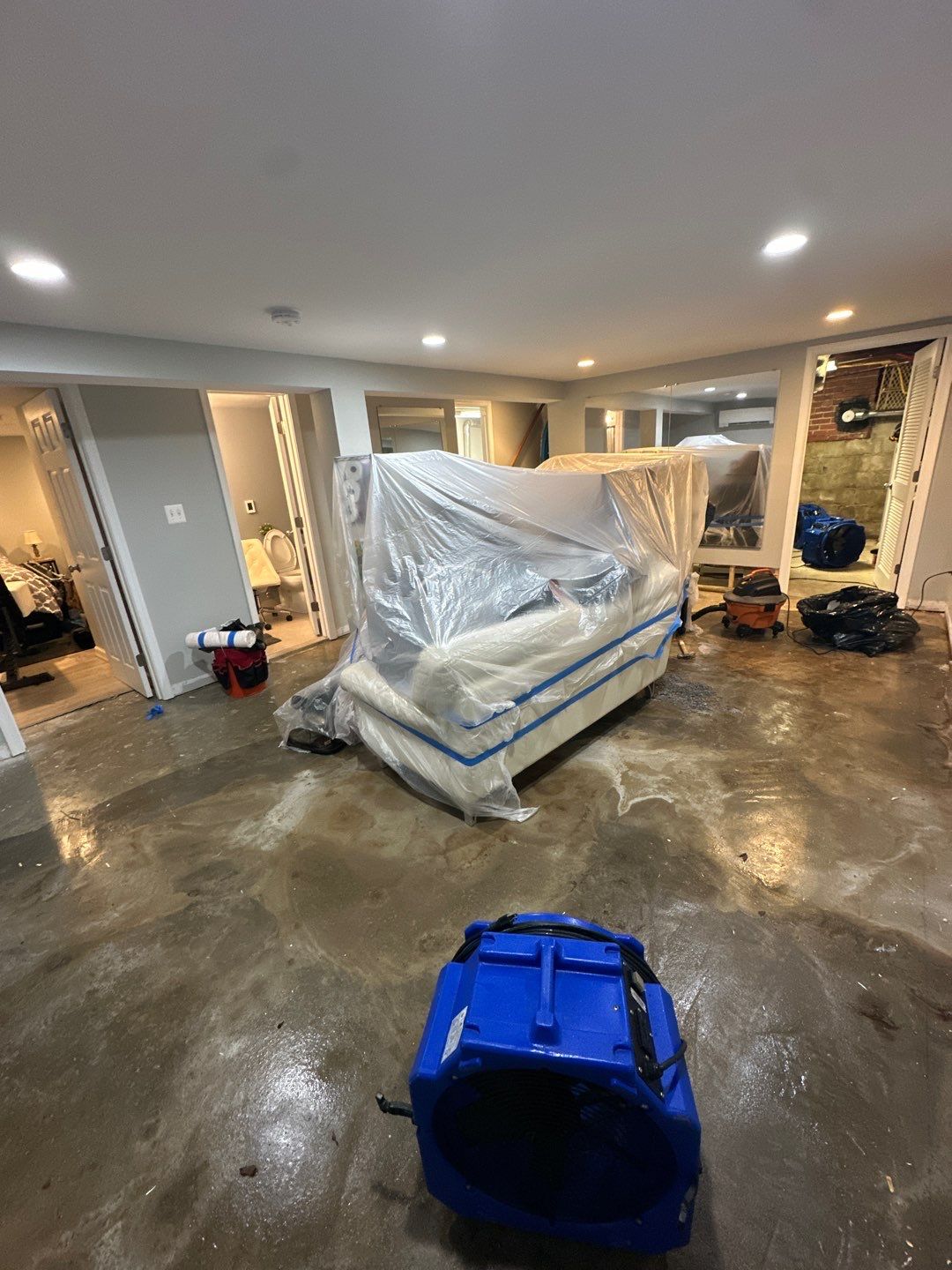 Standing water extraction underway in Arlington water damage restoration, extractors removing pooled water from flooded interior space.