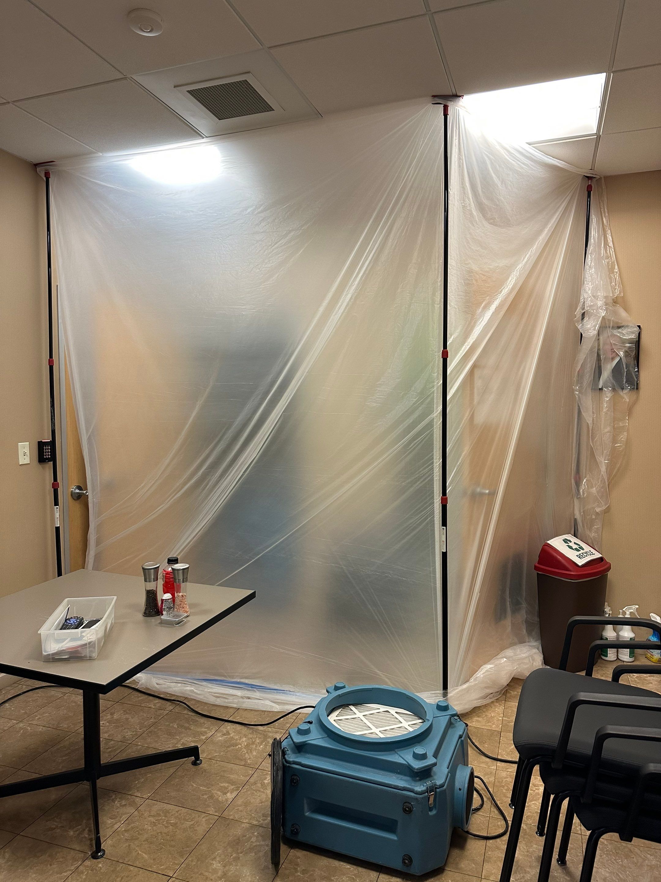 Restored flooring and cleared space following water damage remediation and containment removal.