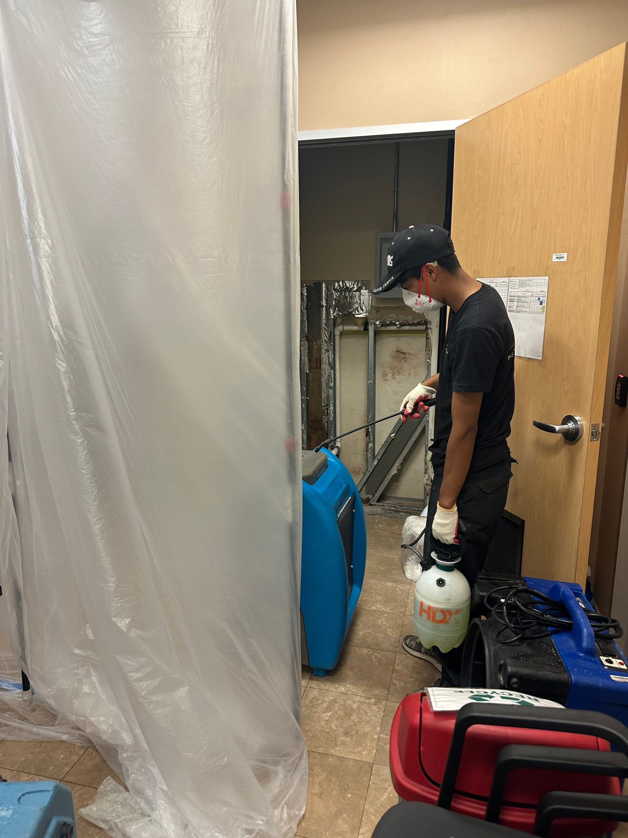 Plastic sheeting containment with dehumidification equipment positioned for moisture control.