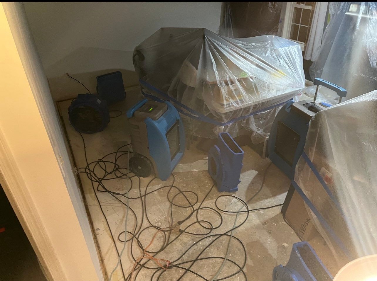 Containment and drying setup during mold remediation, showing equipment placement for controlled moisture removal from ceiling cavity.