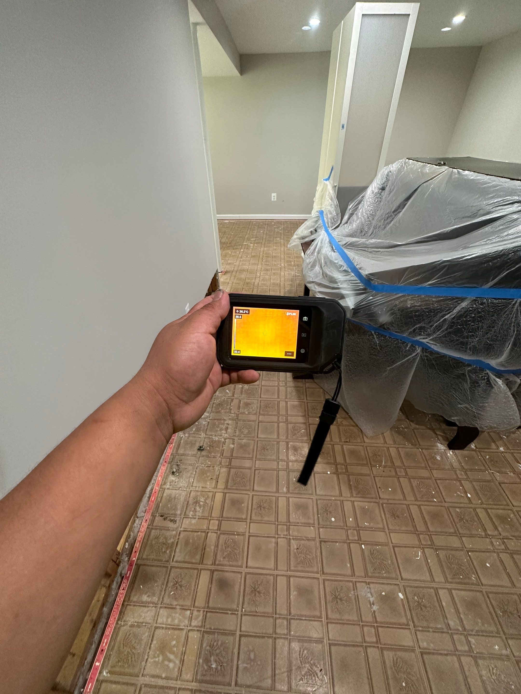 Containment barrier erected during water damage restoration in Sterling, with thermal imaging equipment positioned for moisture mapping.