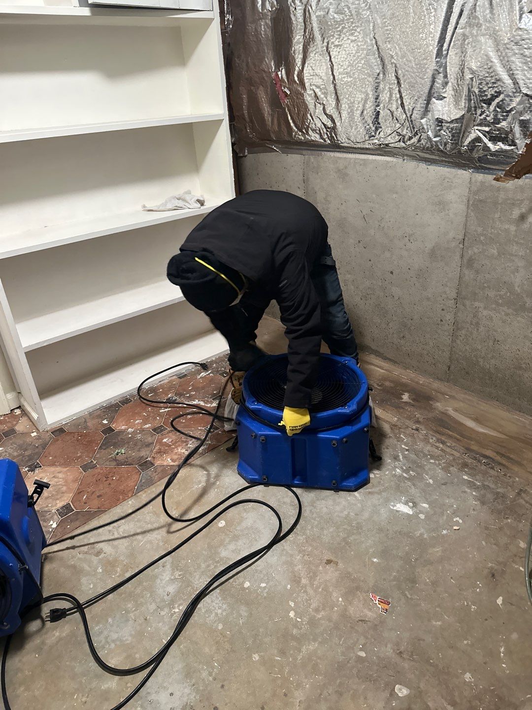 Continued structural drying phase with equipment placement optimized for air circulation and moisture removal.