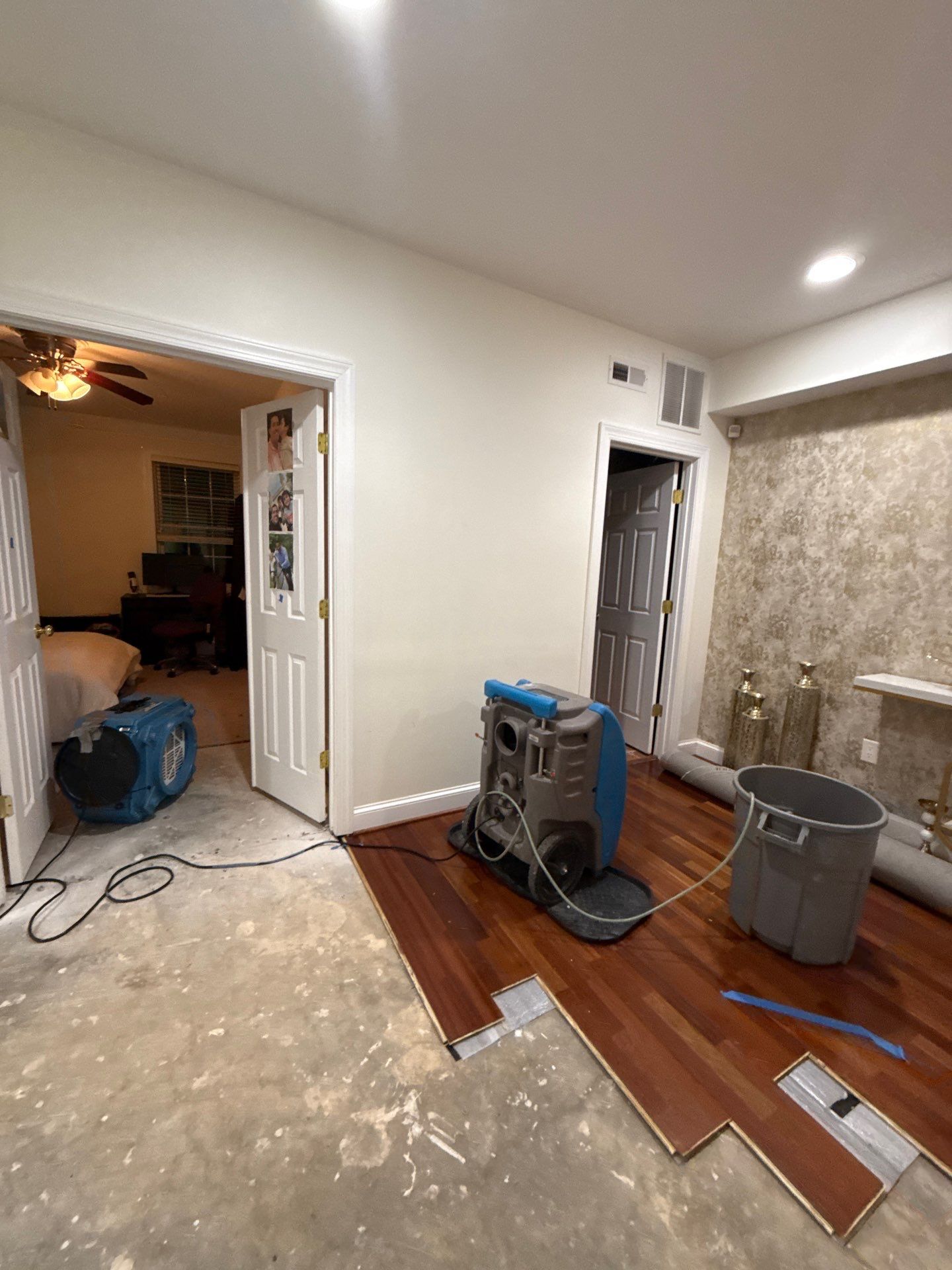 Structural drying in progress with dehumidifiers and air movers during water restoration.