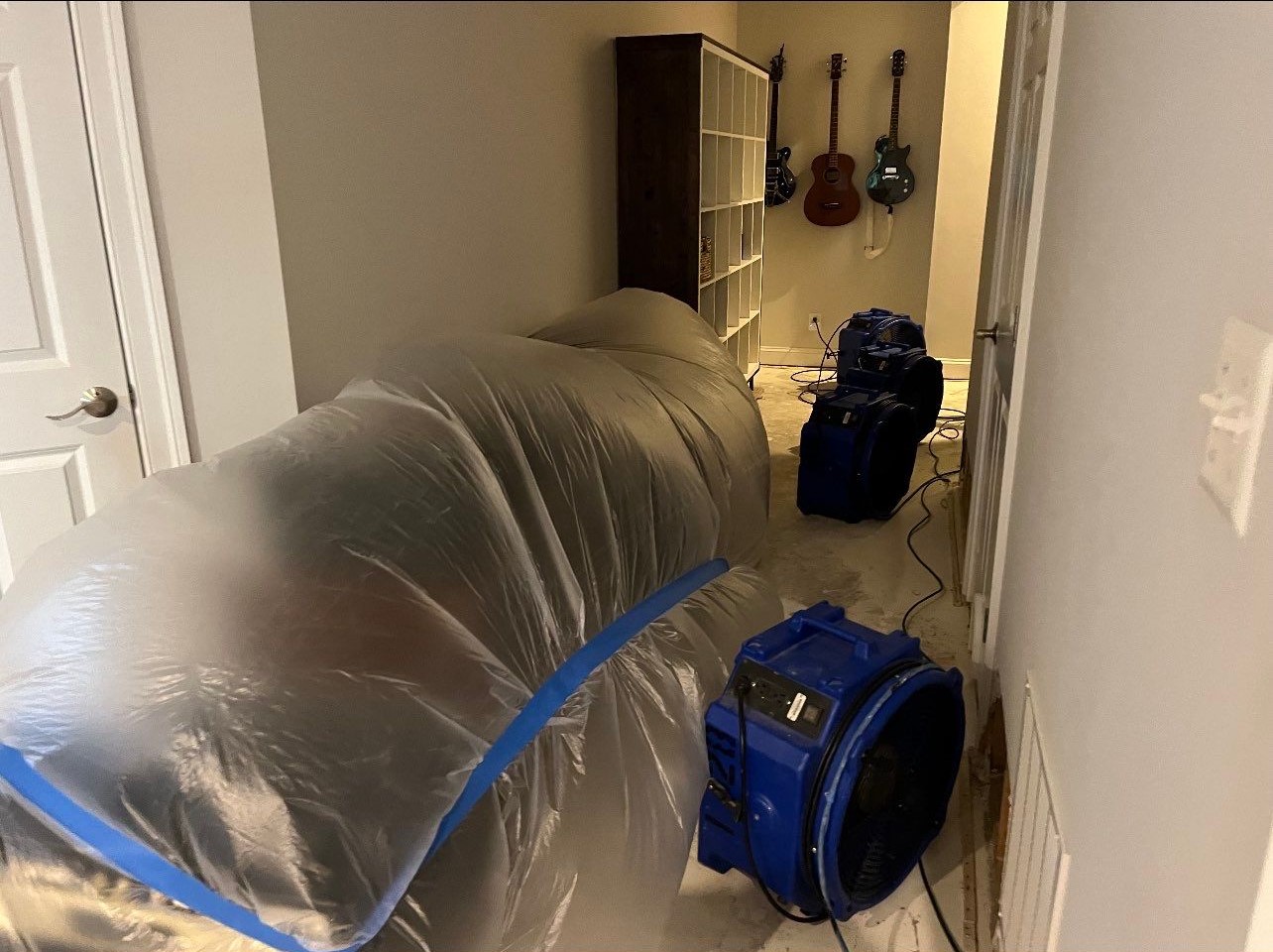 Continued dehumidification and drying phase with equipment monitoring moisture levels in structural cavities.