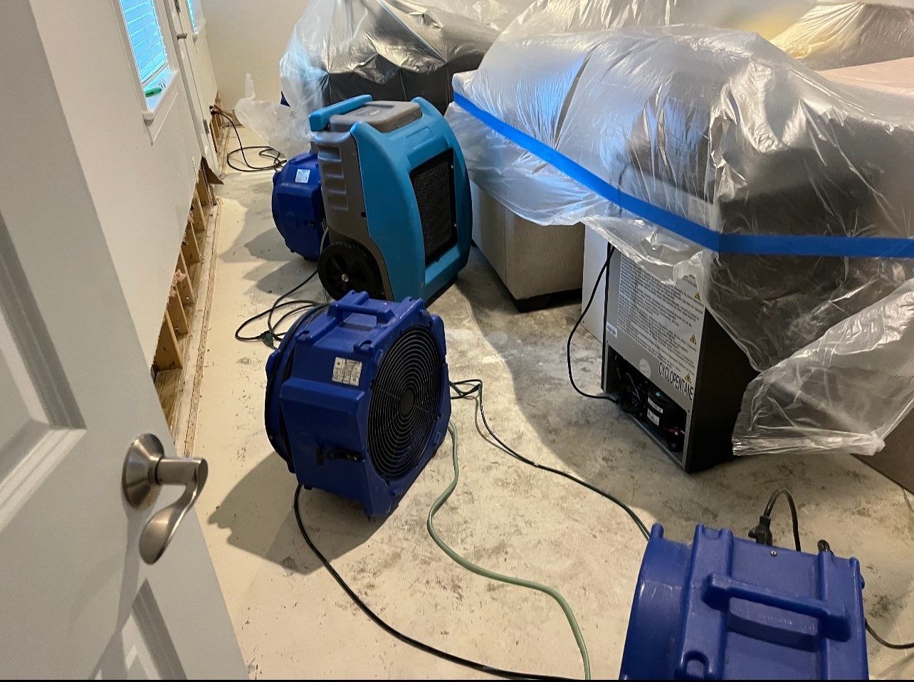 Flooring removal and structural assessment during mold remediation, exposing substrate for drying and treatment.