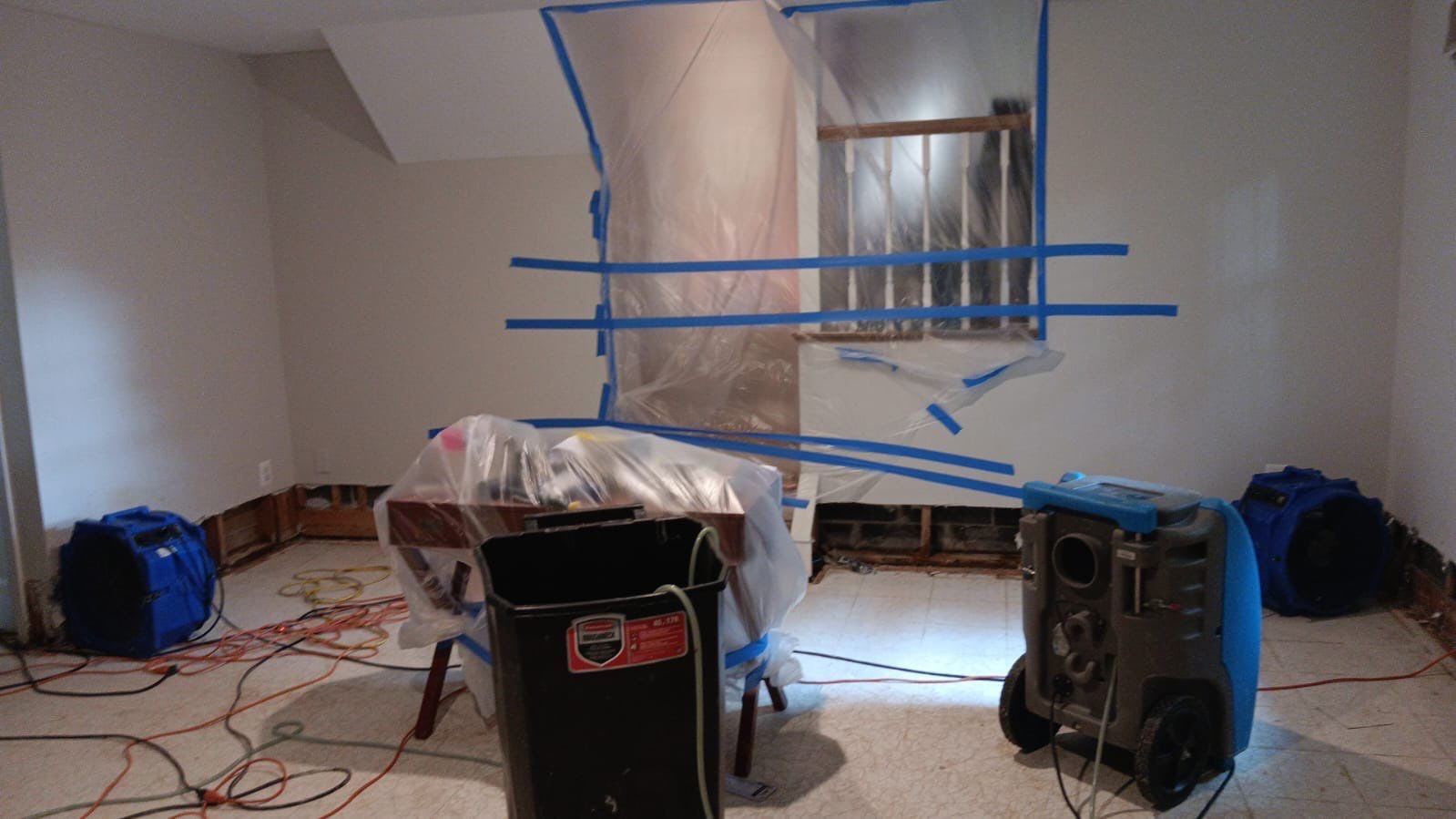 Water damage restoration in Oakton: dehumidifier and drying equipment positioned in affected interior space.