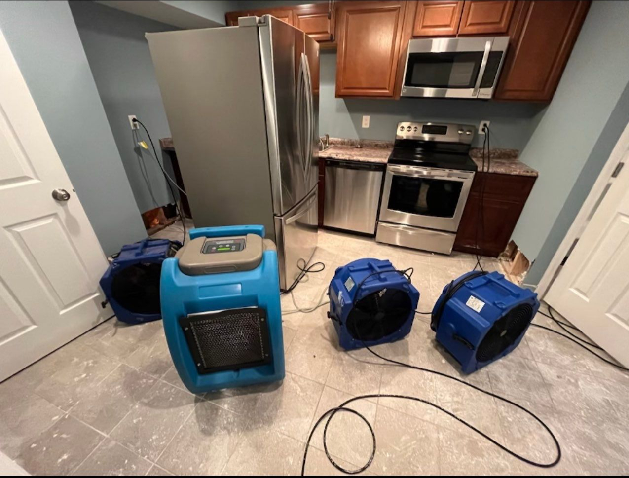 Continued monitoring and air circulation setup as water damage restoration progresses through mid-stage drying.