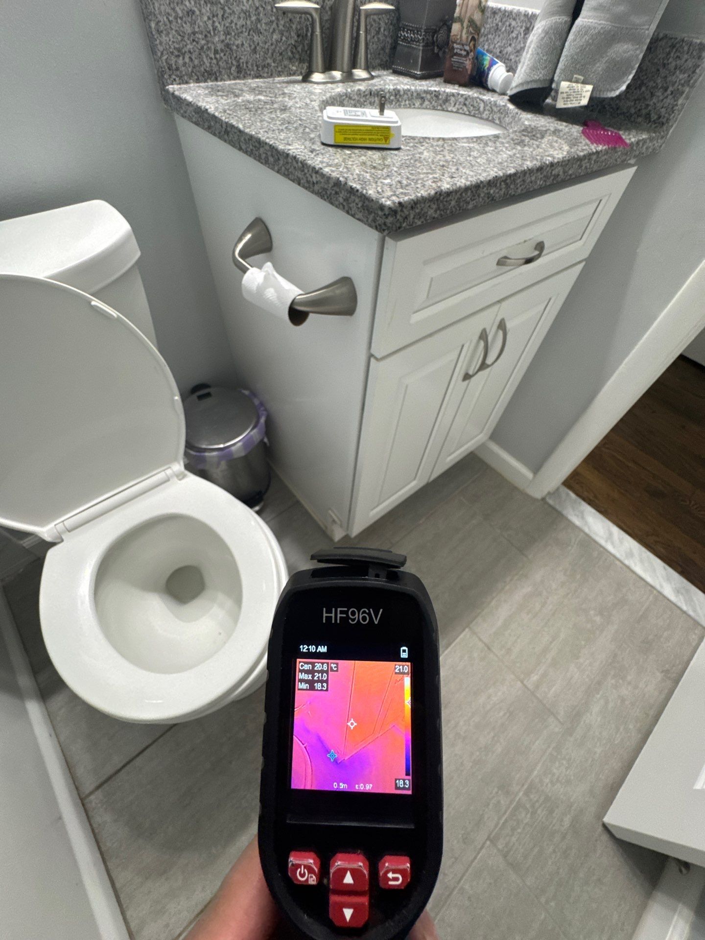 Thermal imaging camera capturing moisture patterns during water damage inspection in Alexandria.