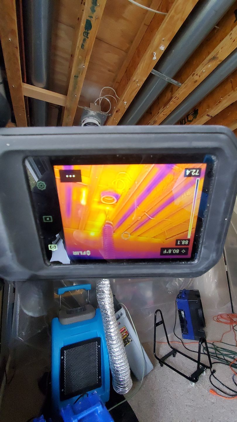 Monitoring setup with dehumidifier and containment barrier during active water restoration.