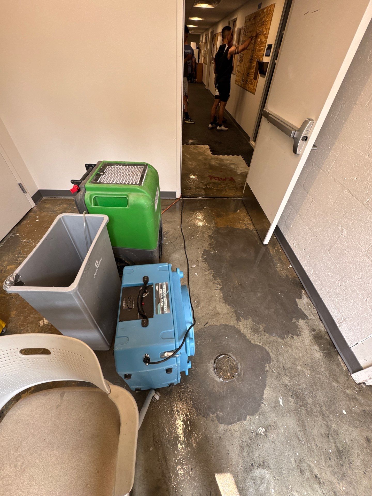 Water damage drying in progress, dehumidification equipment operating to remove residual moisture from building materials.