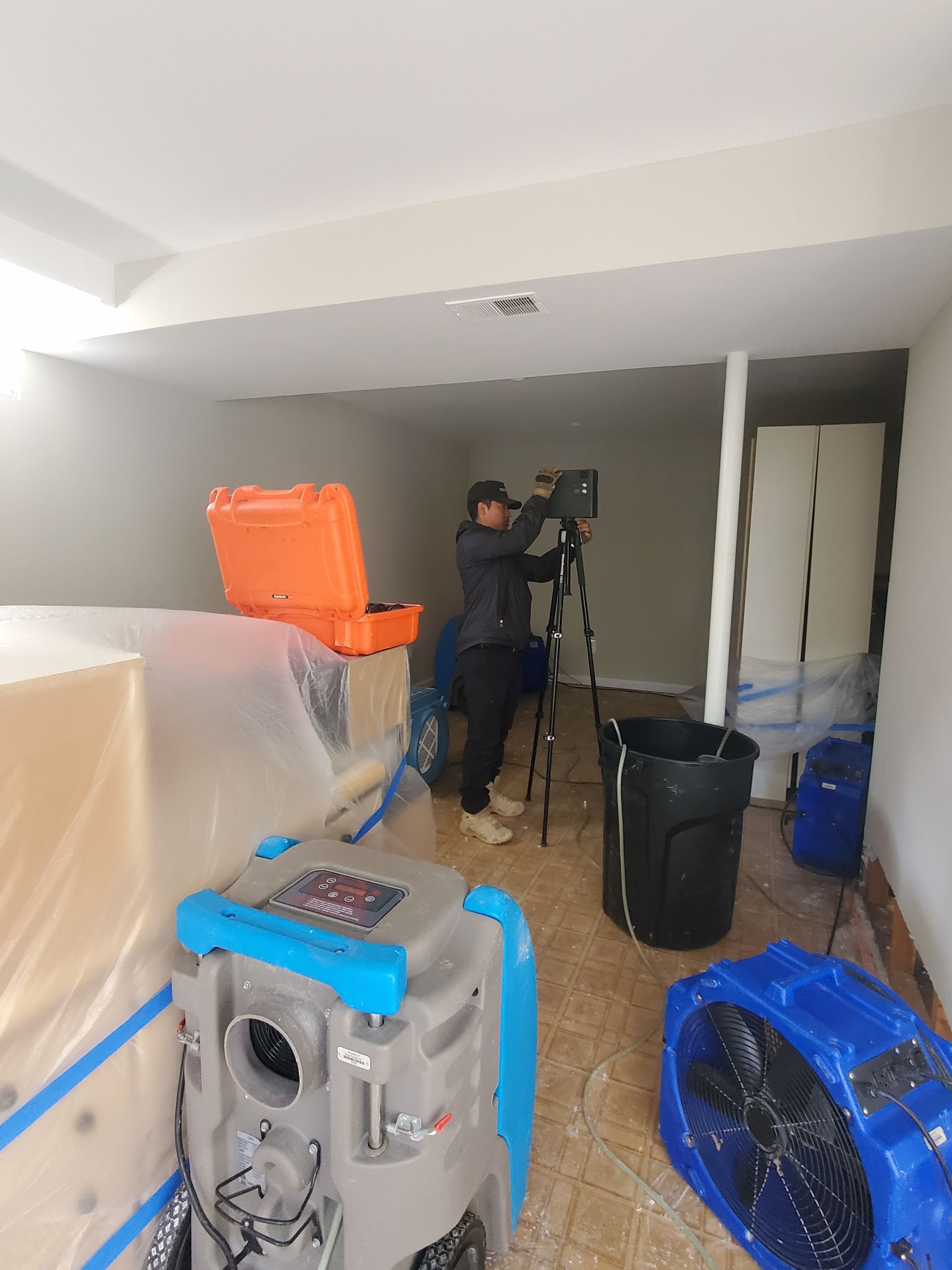 Water damage restoration in Sterling: dehumidifier and drying equipment deployed in affected interior space.