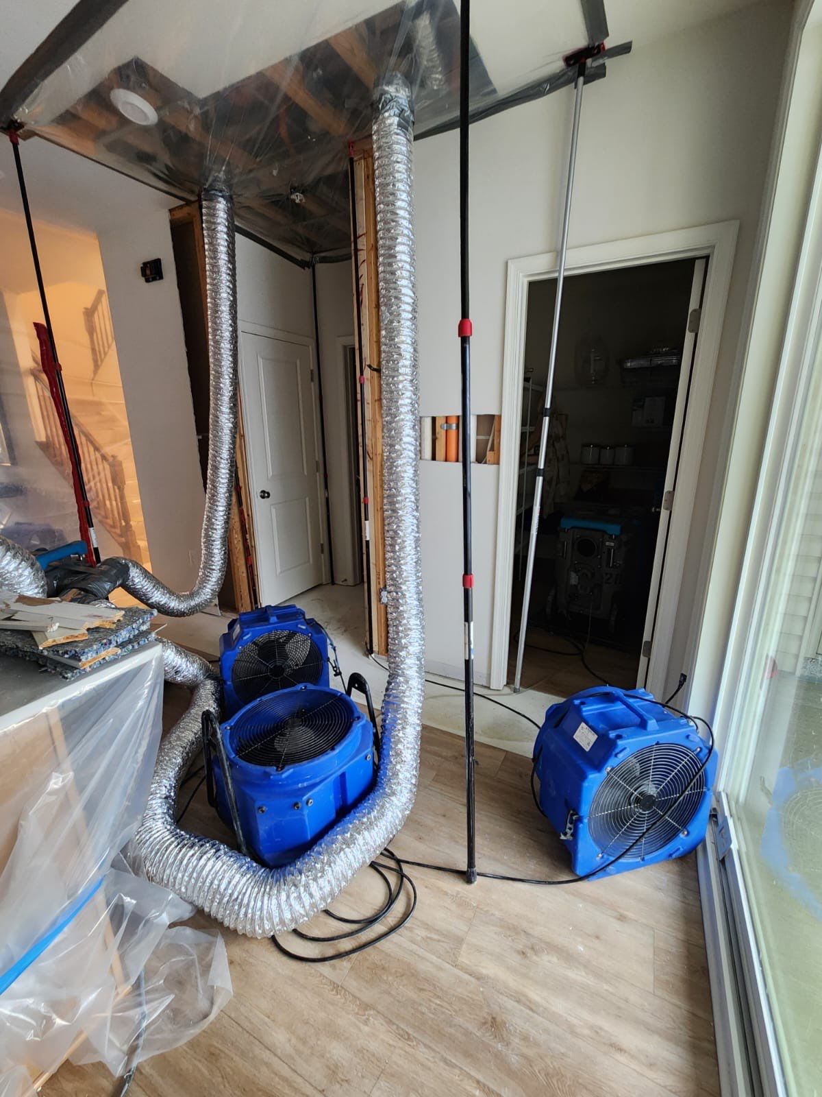New drywall installation beginning on framed walls following water damage extraction and drying.