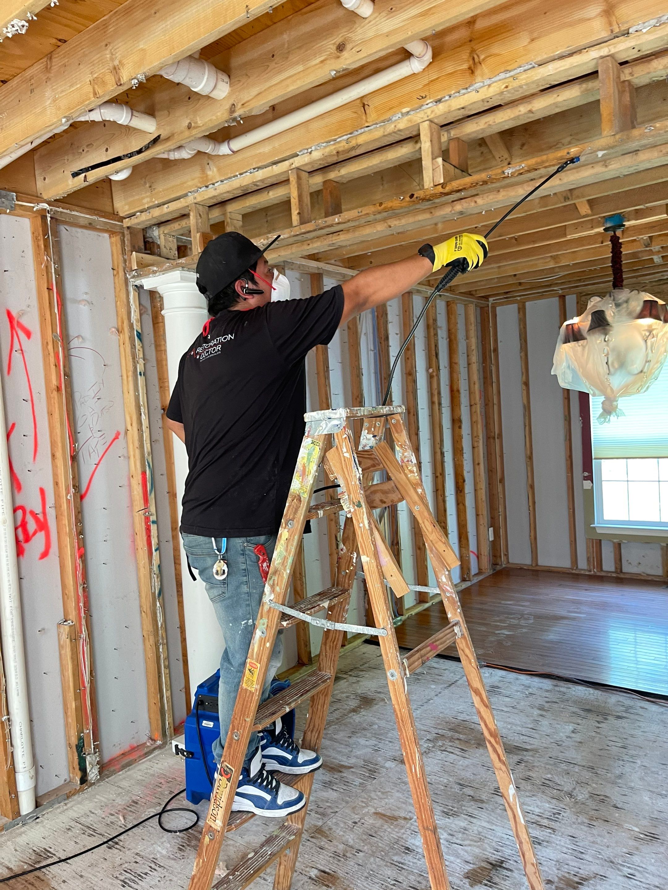 Mid-stage drying process showing dehumidifier and air movers managing moisture during water restoration work.