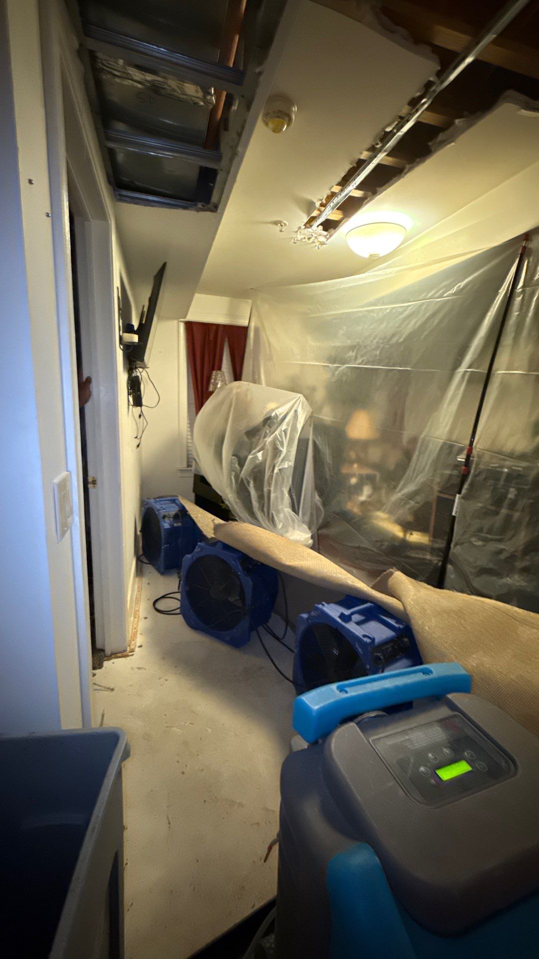 Dehumidification equipment positioned to dry structural cavities after water removal.