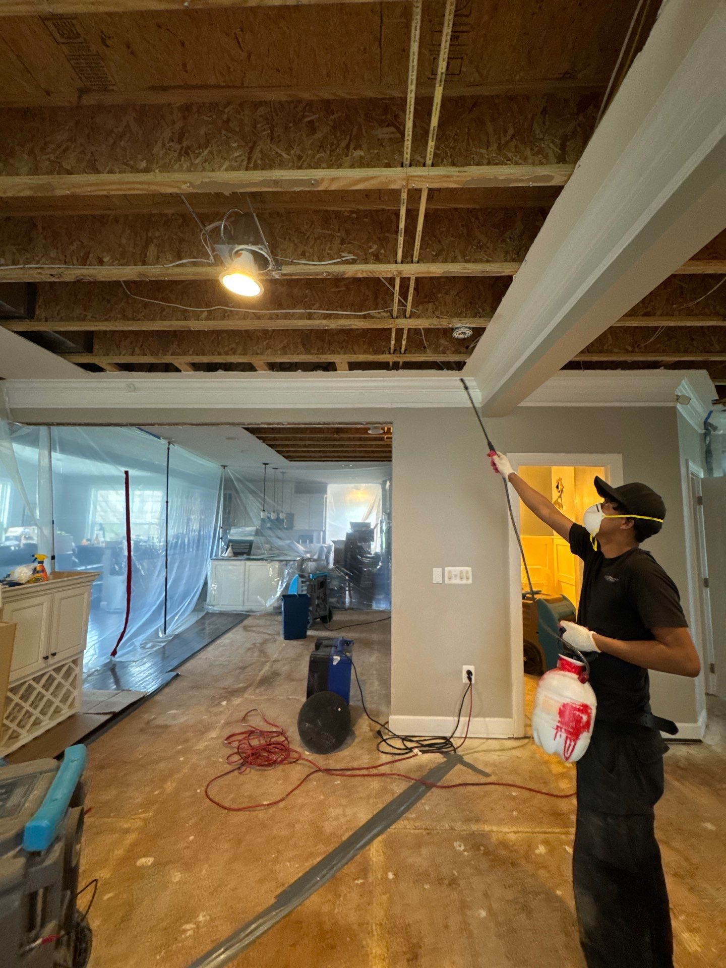 Standing water extraction underway within sealed containment during mold remediation.