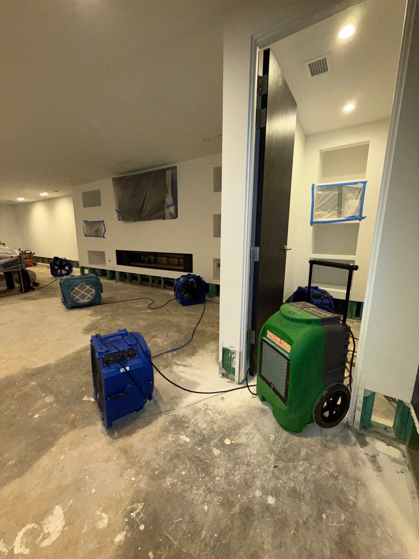 Ashburn water restoration in progress: exposed wall cavities being dried, with moisture monitoring and ventilation equipment in place.