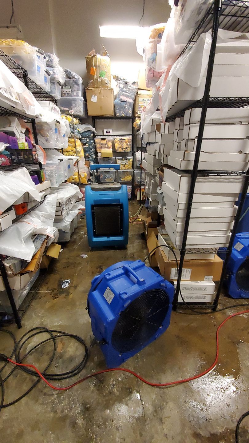 Standing water extraction underway in Springfield water damage restoration, wet flooring visible.