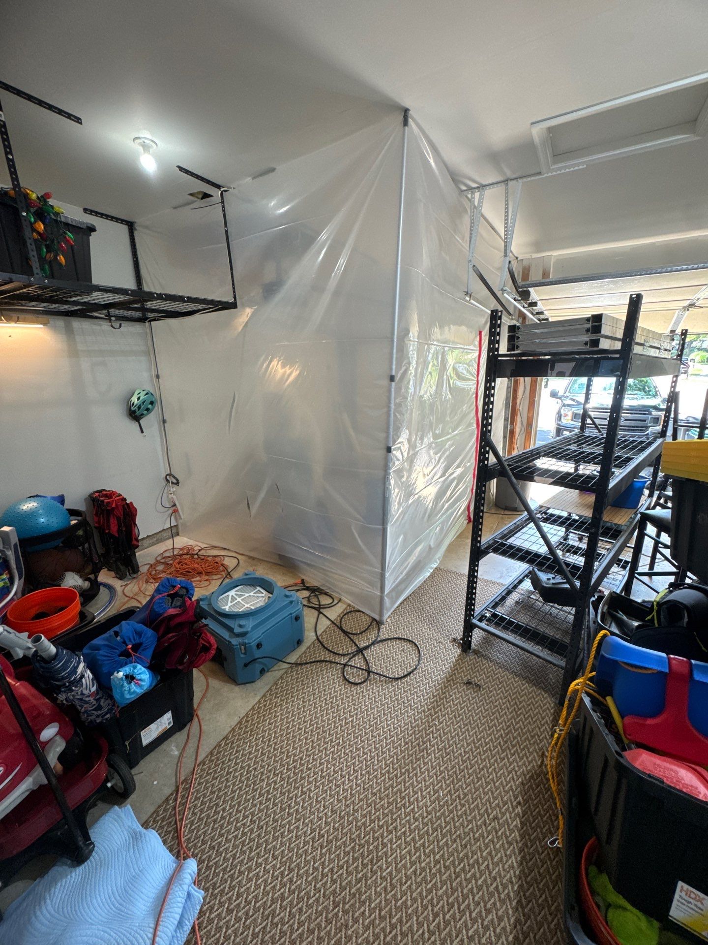 Dehumidifiers and air movers positioned for moisture removal in affected ceiling area.