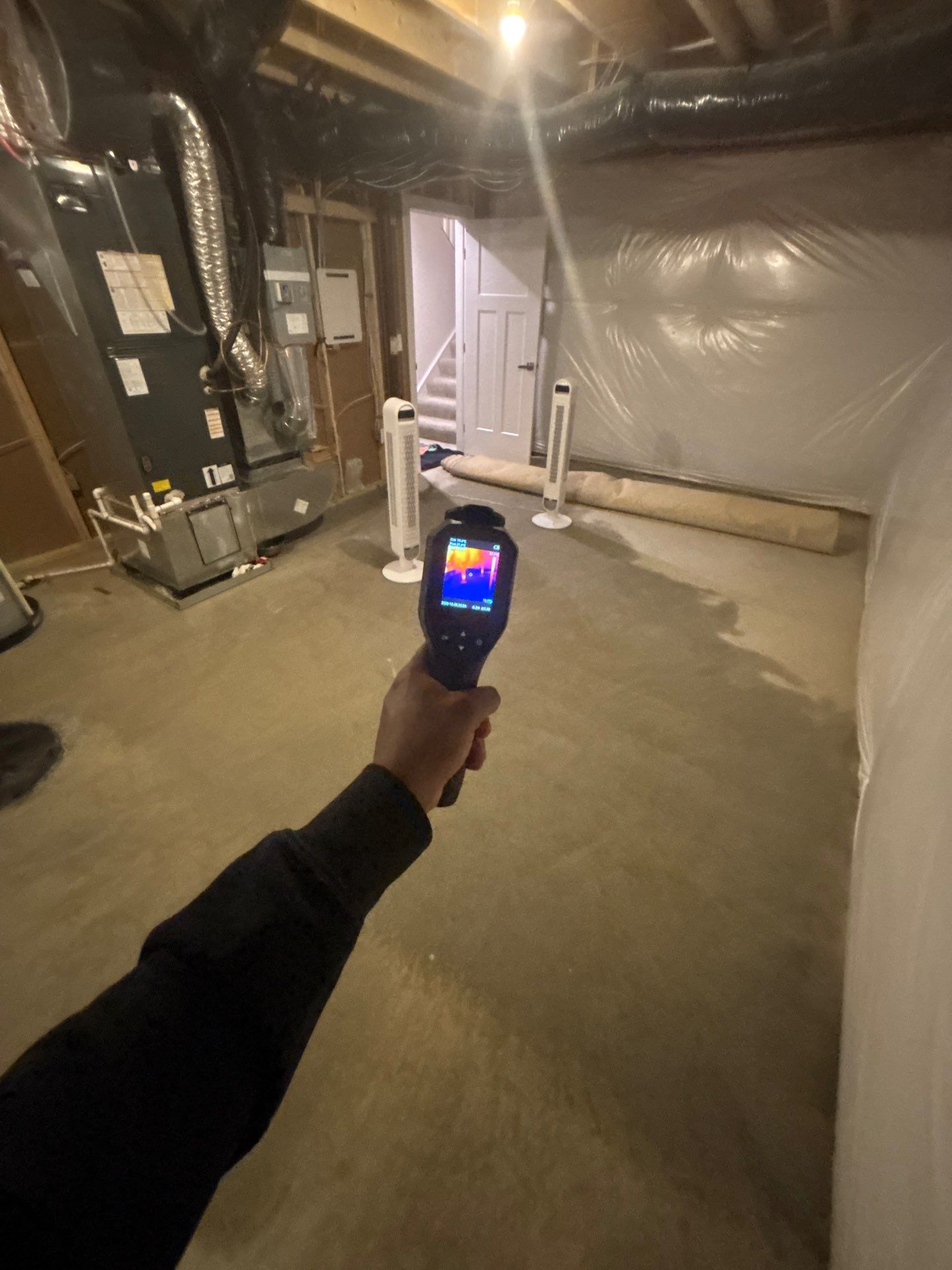 Thermal imaging camera capturing moisture patterns in Stafford water damage restoration assessment.