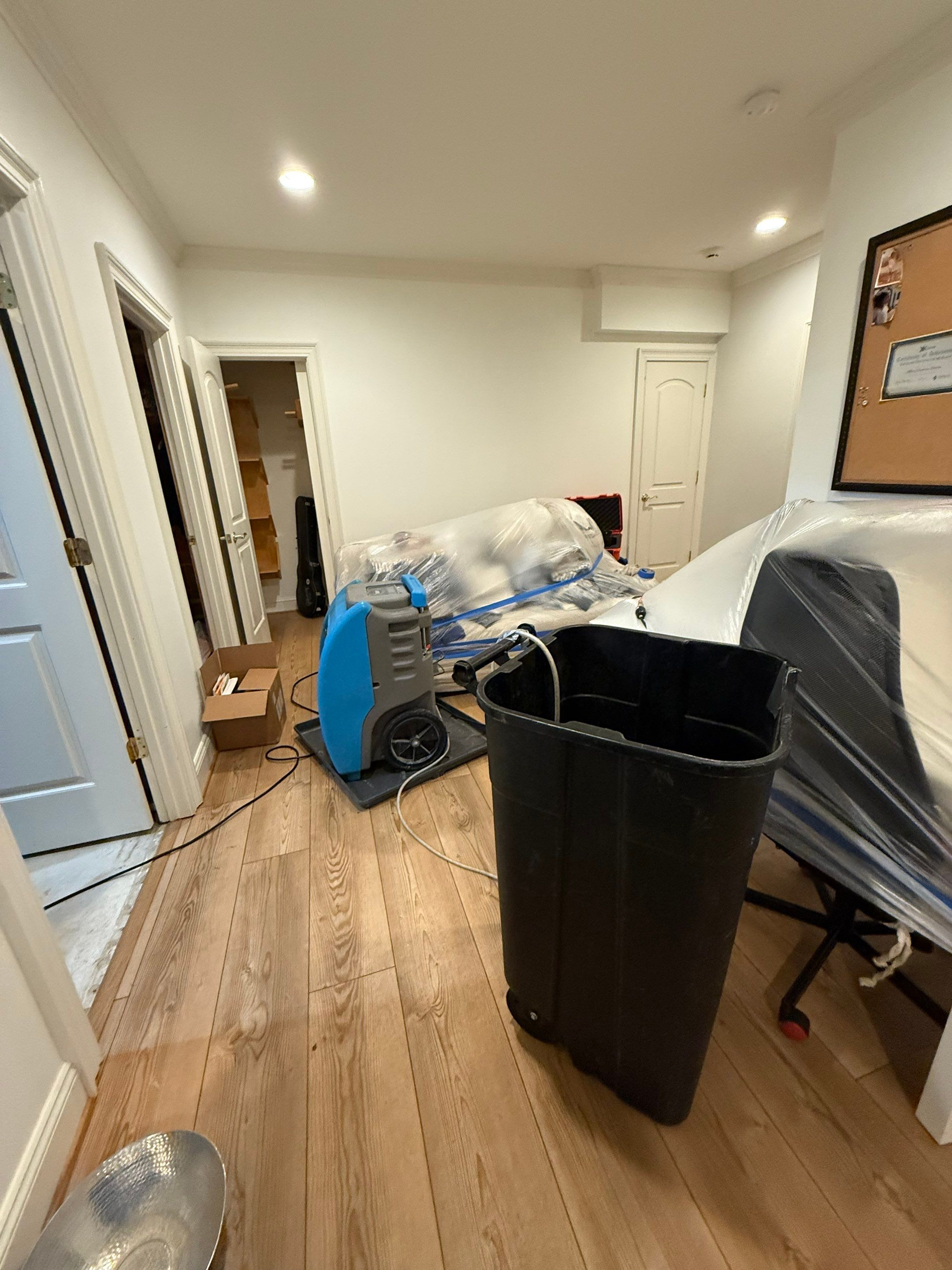 Flooring assessment and preparation for remediation in water-damaged room.