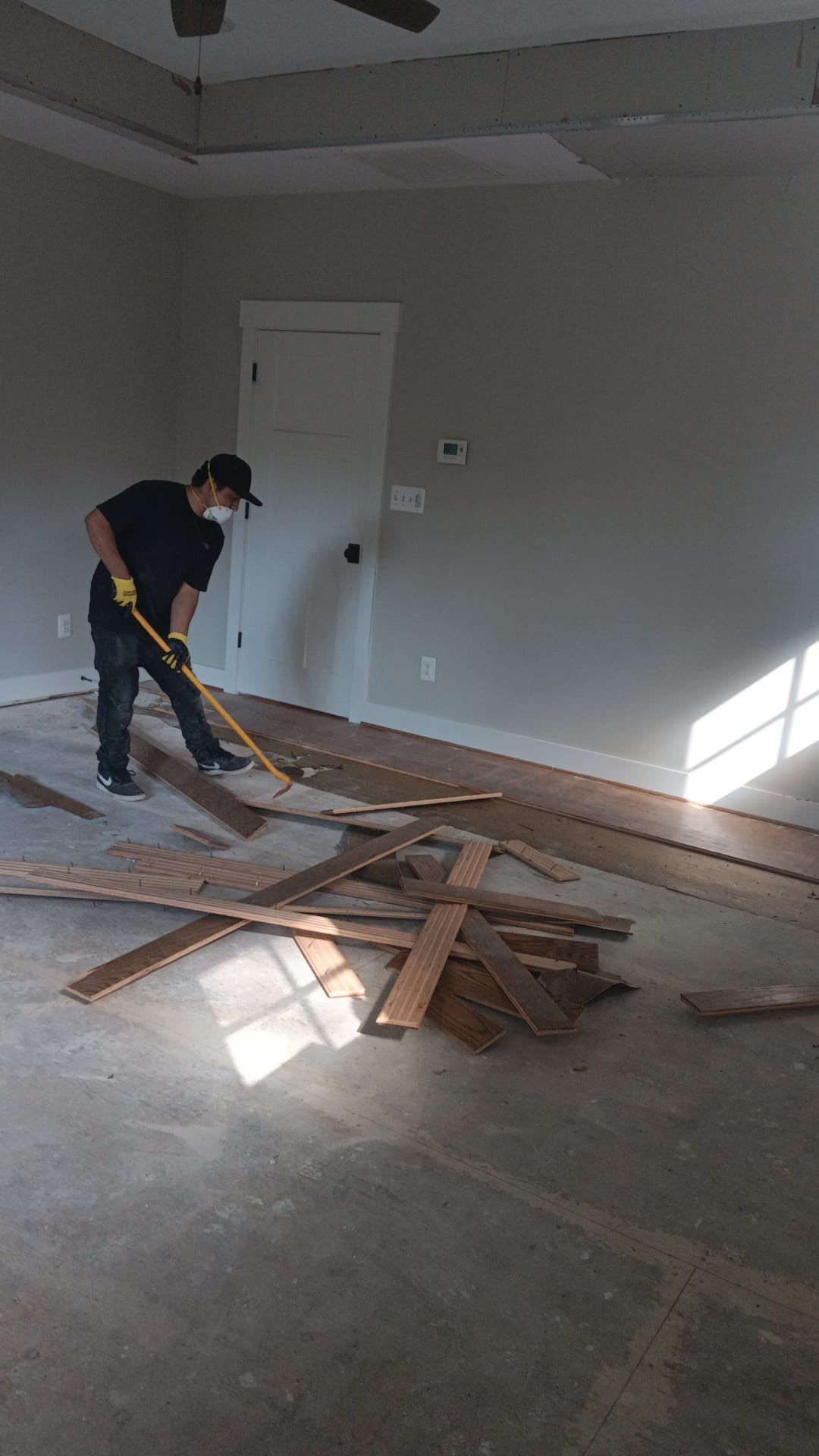 Standing water extraction underway in Falls Church water damage restoration, dehumidifiers positioned for structural drying.