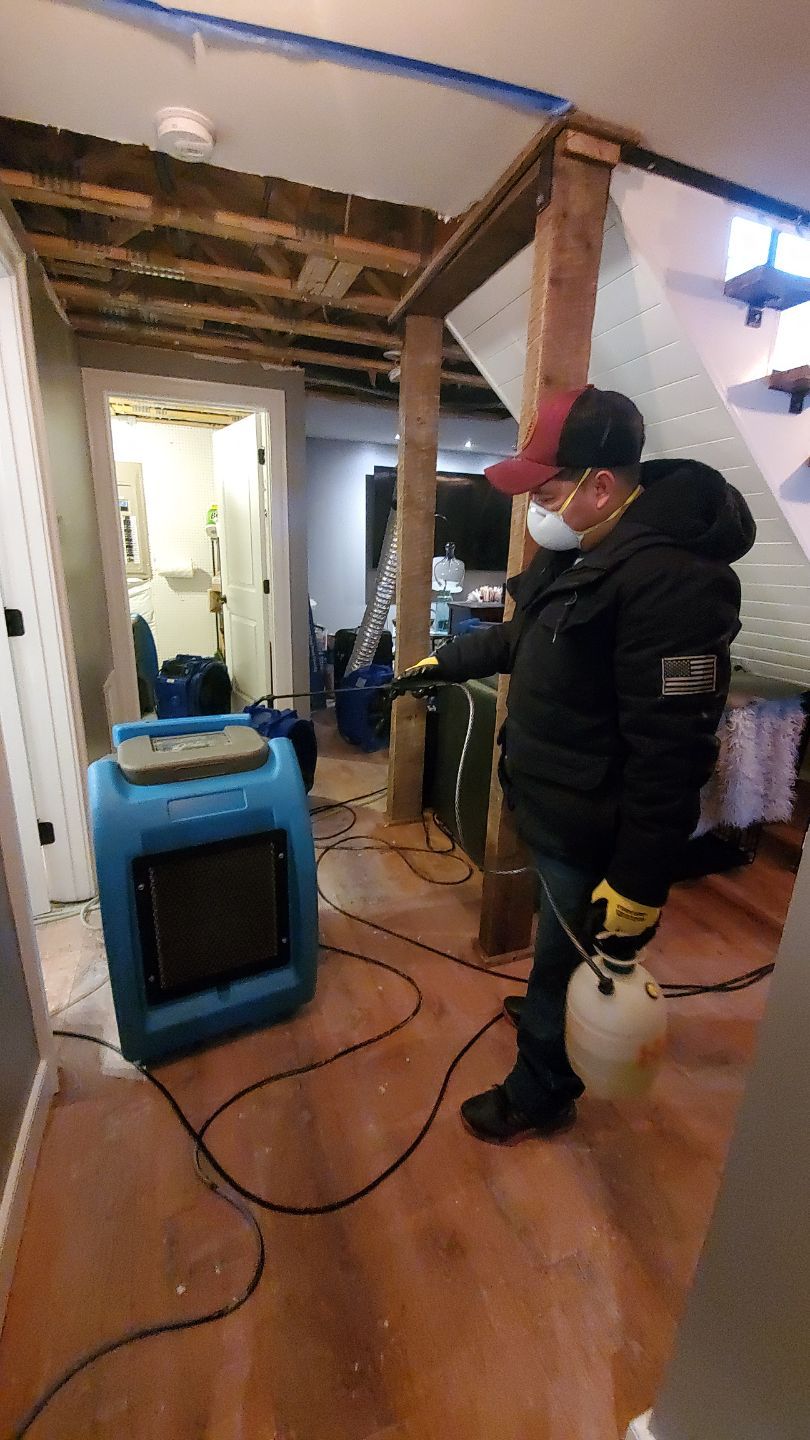 Water damage restoration in Middleburg: dehumidifier and drying equipment positioned in affected room during initial assessment phase.