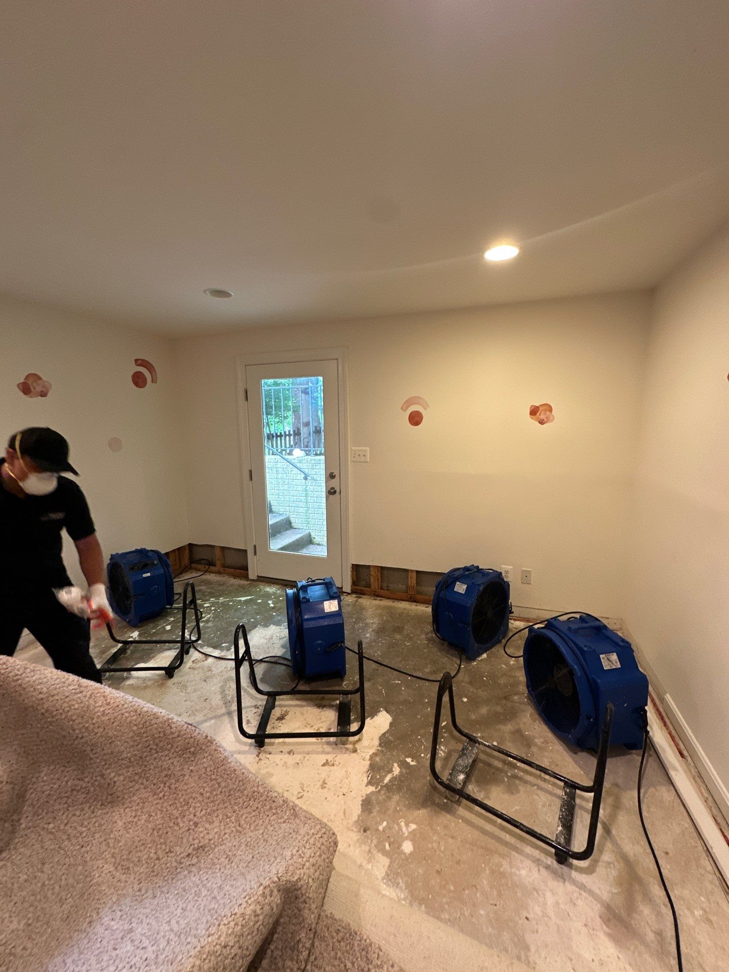Dehumidifiers and air movers positioned for structural drying in water restoration project.