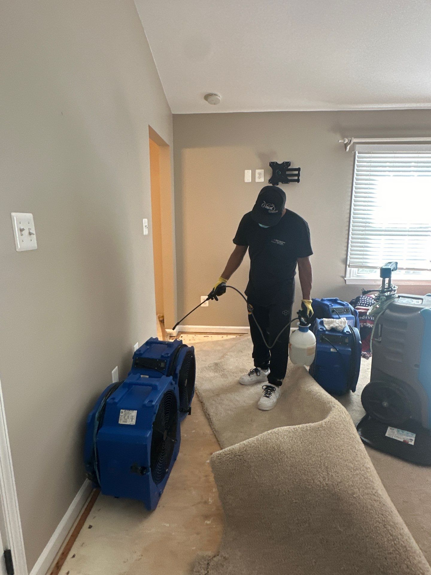 Water-damaged carpet and flooring in Burke home with dehumidification equipment positioned for structural drying.