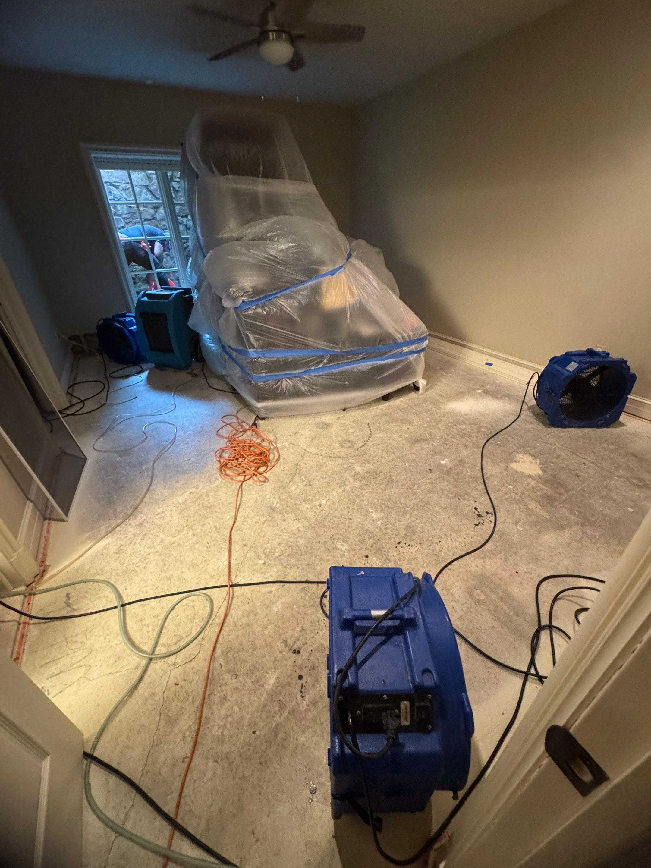 Flooring removal underway inside containment barrier during McLean mold remediation work.